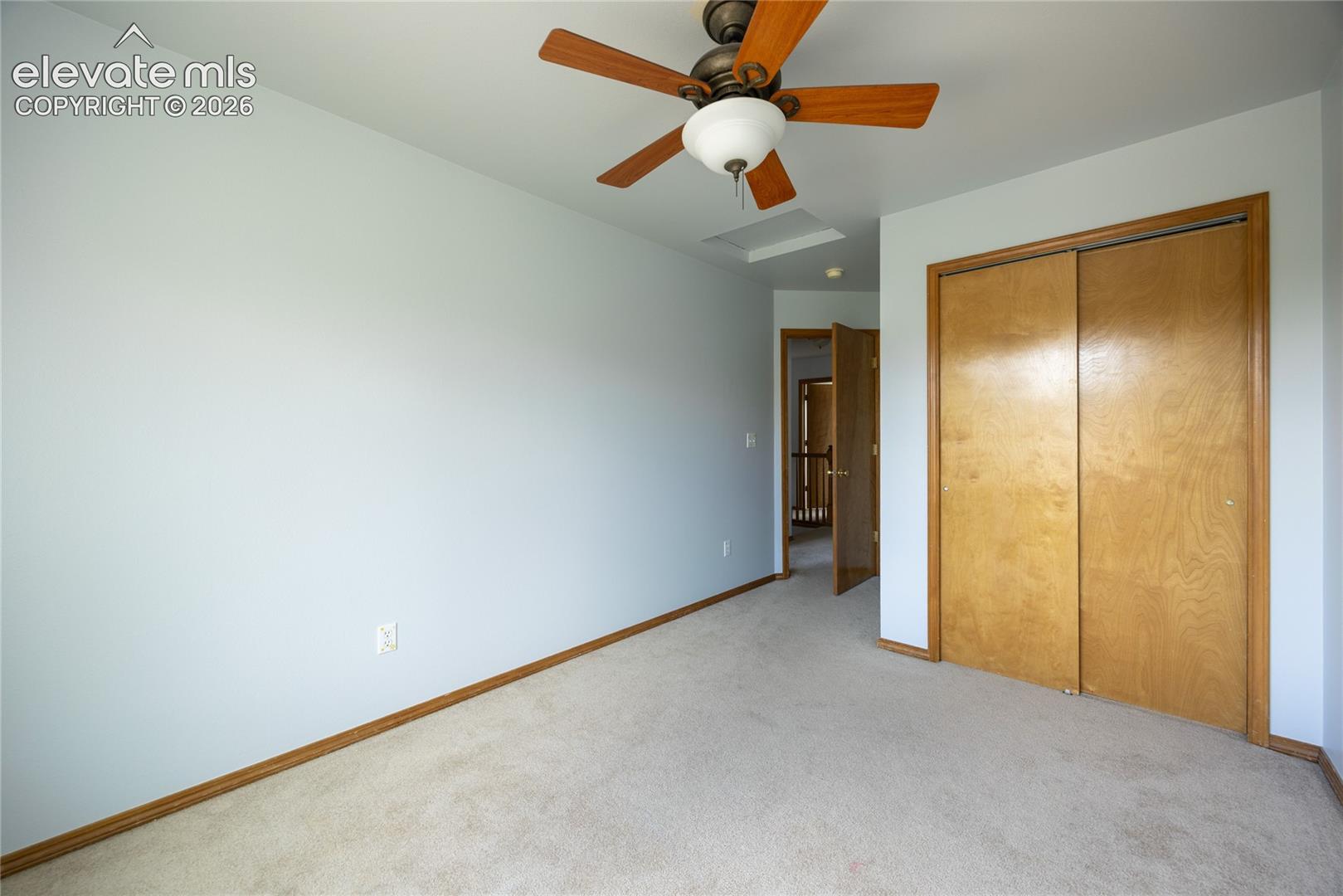 Ceiling fan, neutral wall color, carpet flooring, wood-finish bi-fold closet doors, wood-finish trim