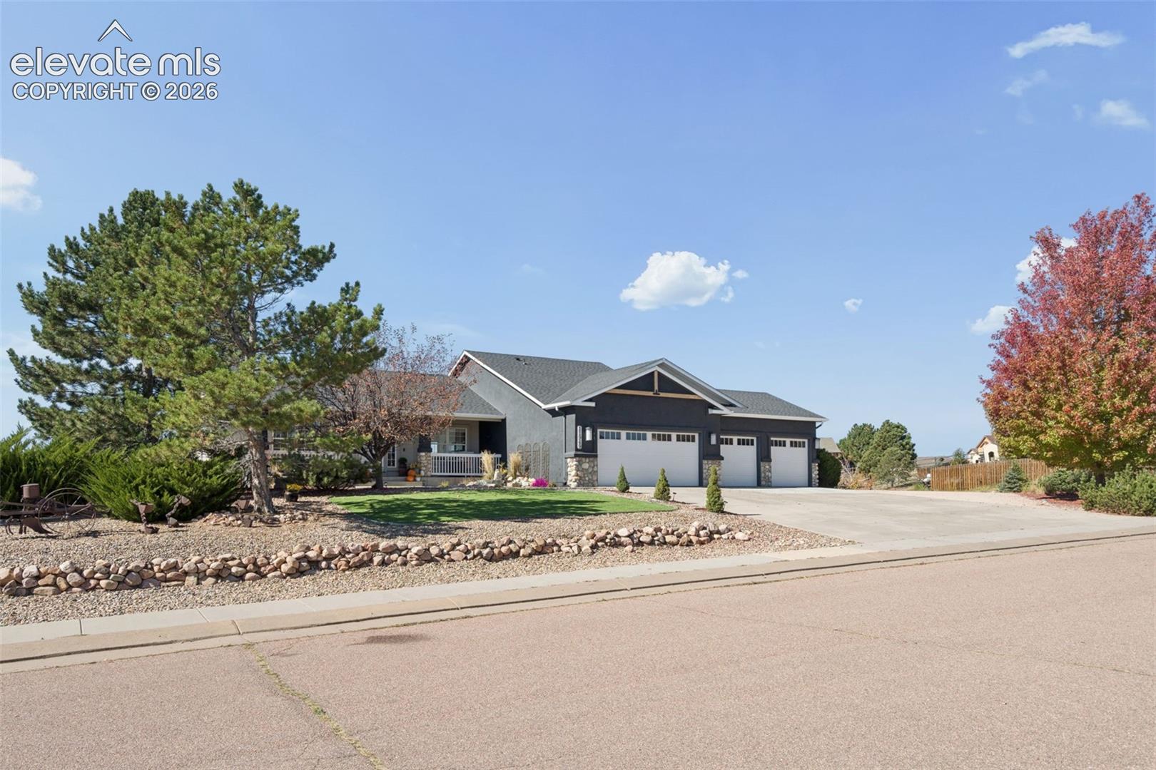 Modern ranch-style home featuring a stone facade and dark siding