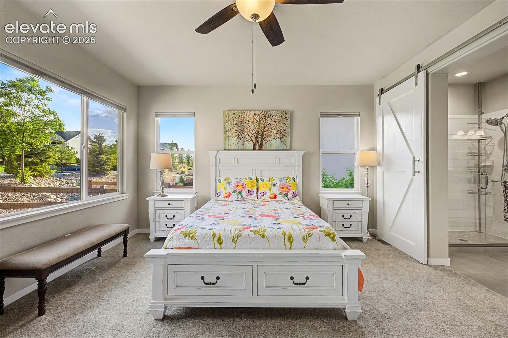 Spacious primary suite offers a serene main-level retreat with abundant natural light and plenty of room to relax and unwind.