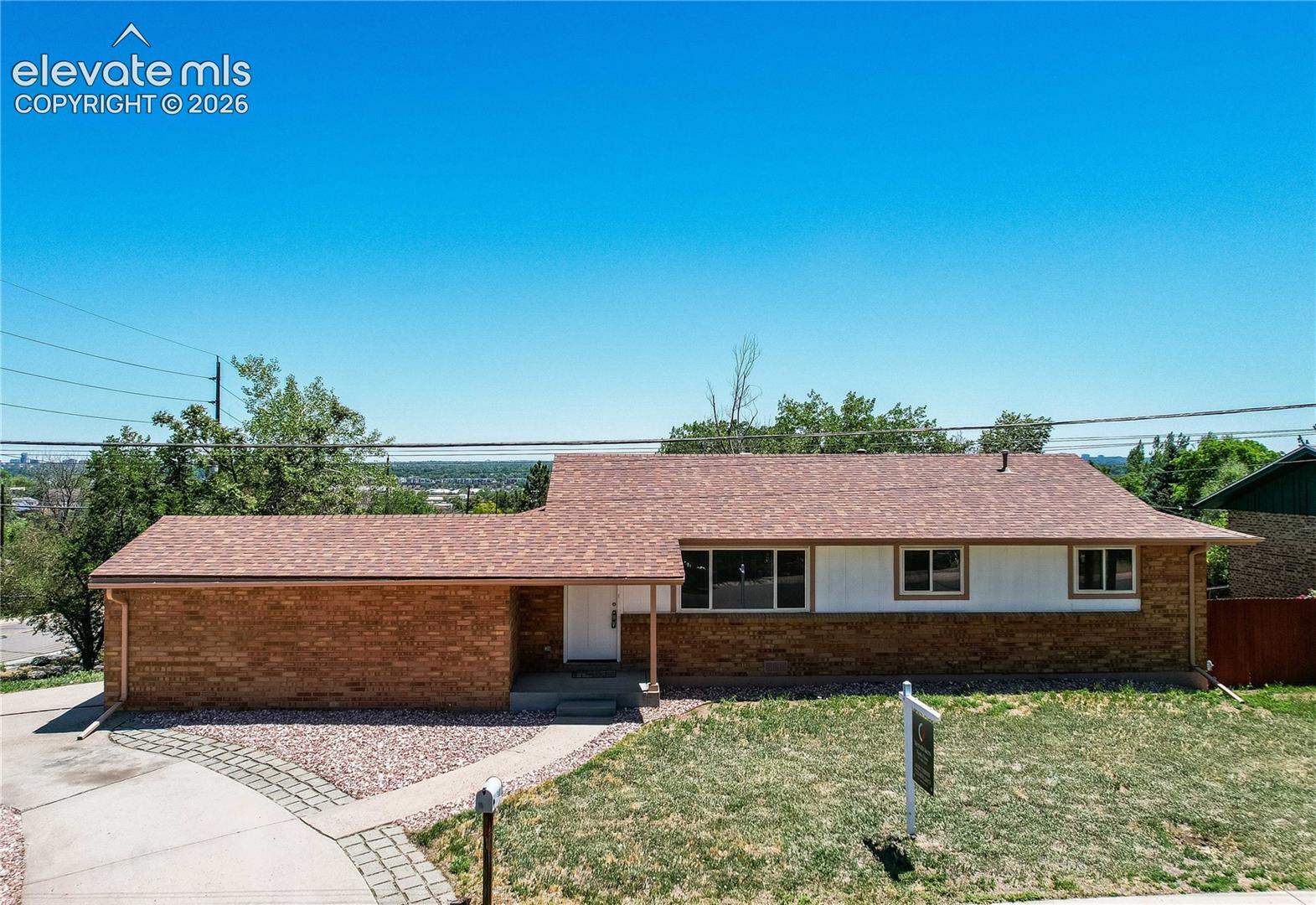 Single-story ranch exterior featuring a multi-tonal brick facade, horizontal siding, and a shingled roof