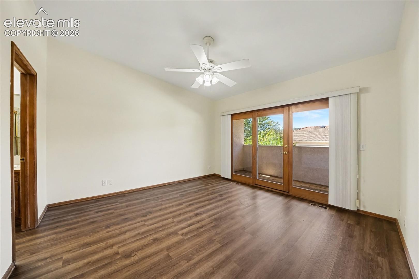 New paint and LVP flooring, ceiling fan, and doors to balcony