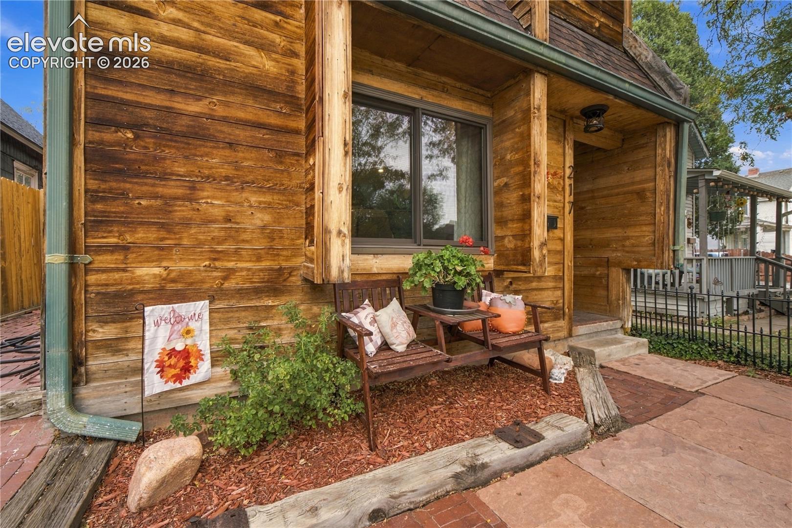 Exterior facade featuring horizontal wood-plank siding, a covered entryway, and a prominent timber-framed window casing