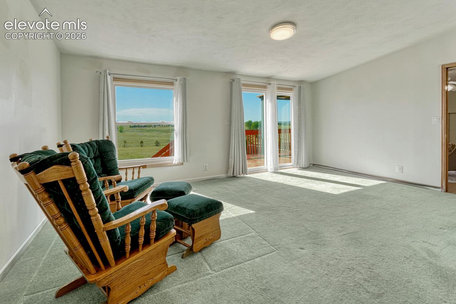 main level primary bedroom with walkout to deck and incredible views of the mountains and prarie 