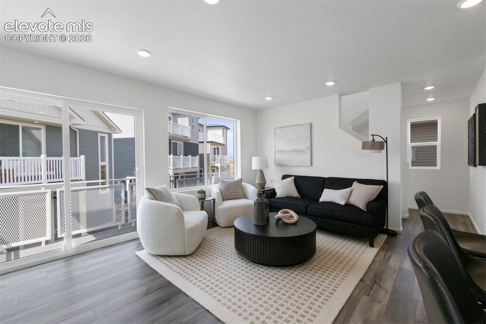 Spacious living area featuring wood-finish flooring, recessed lighting, and large windows
*photos of a model home*