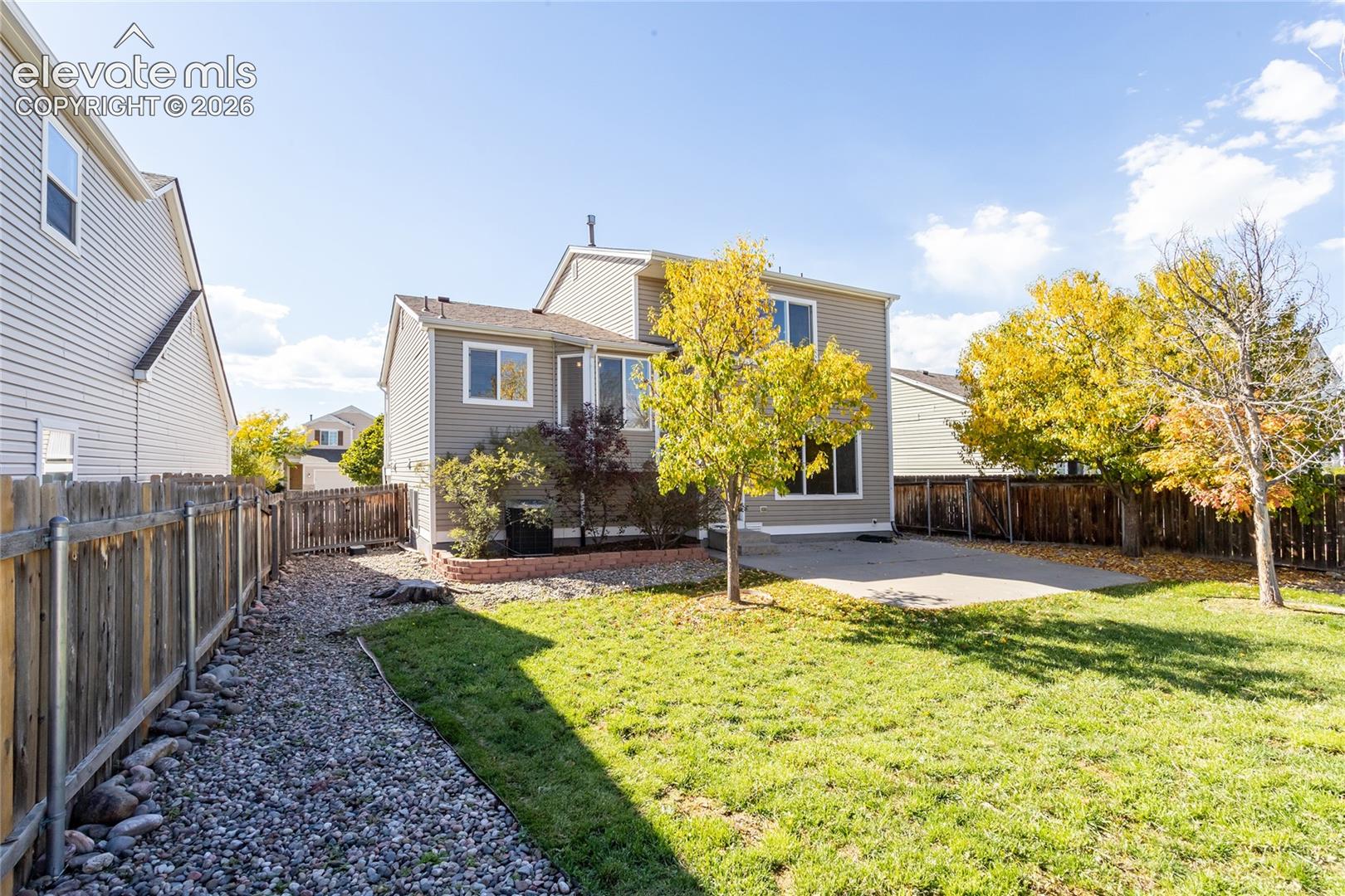 A spacious back lawn framed by landscape stone borders offers plenty of room for play, pets, and outdoor fun[