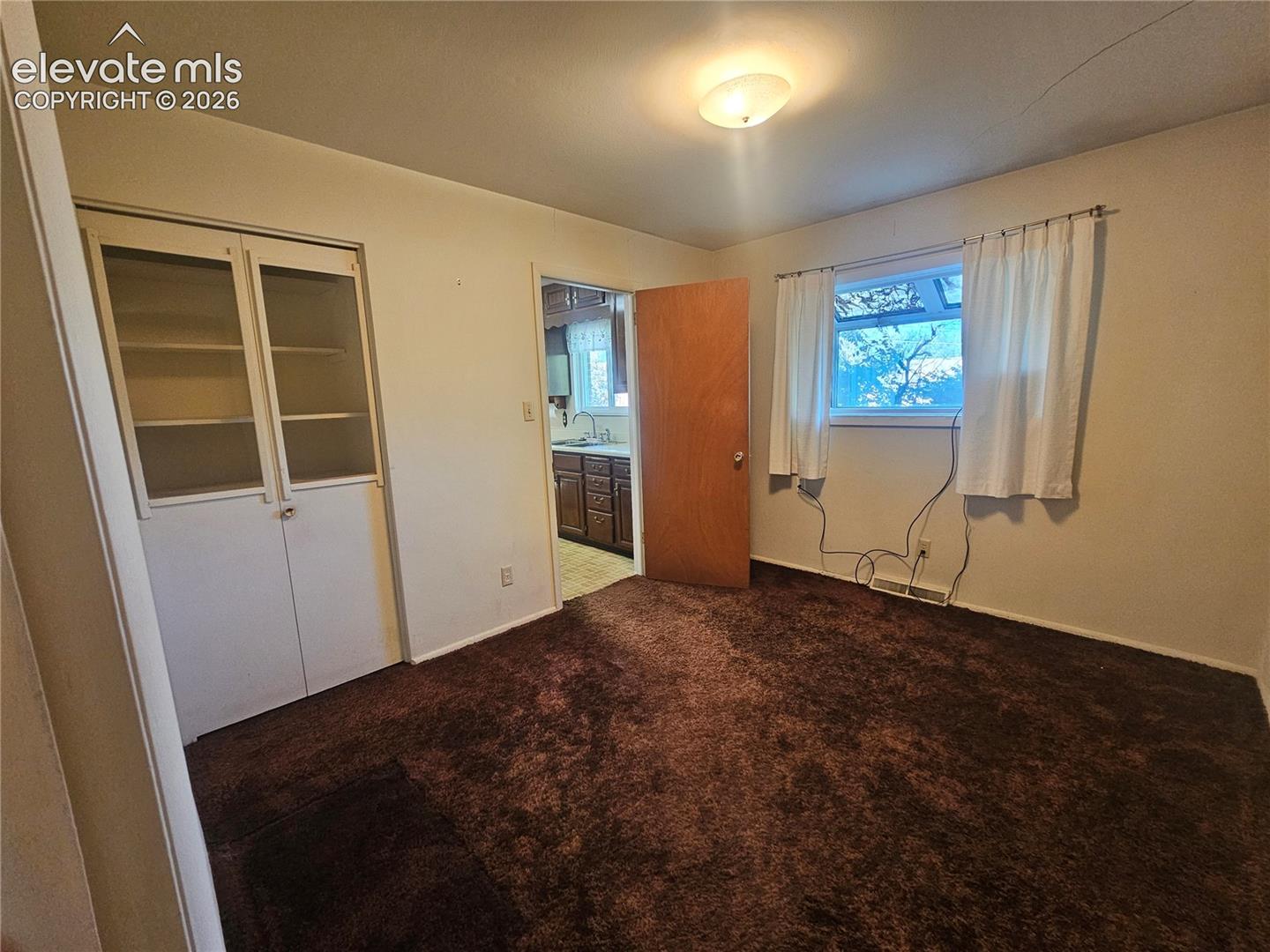 Dining room w/ Built-in cabinetry with glass panel doors, and a showcase window.
