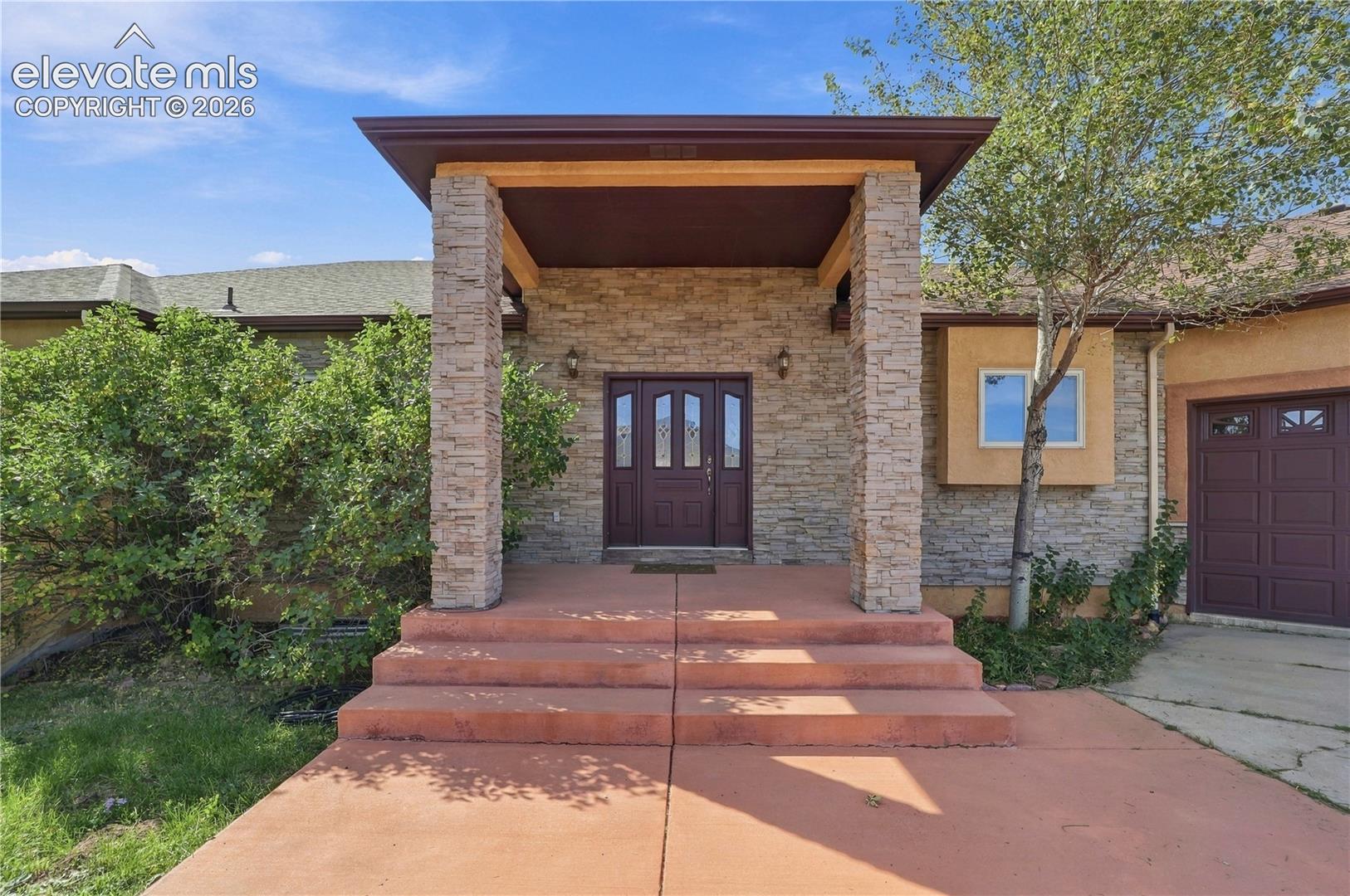 Stacked stone exterior with welcoming covered entry
