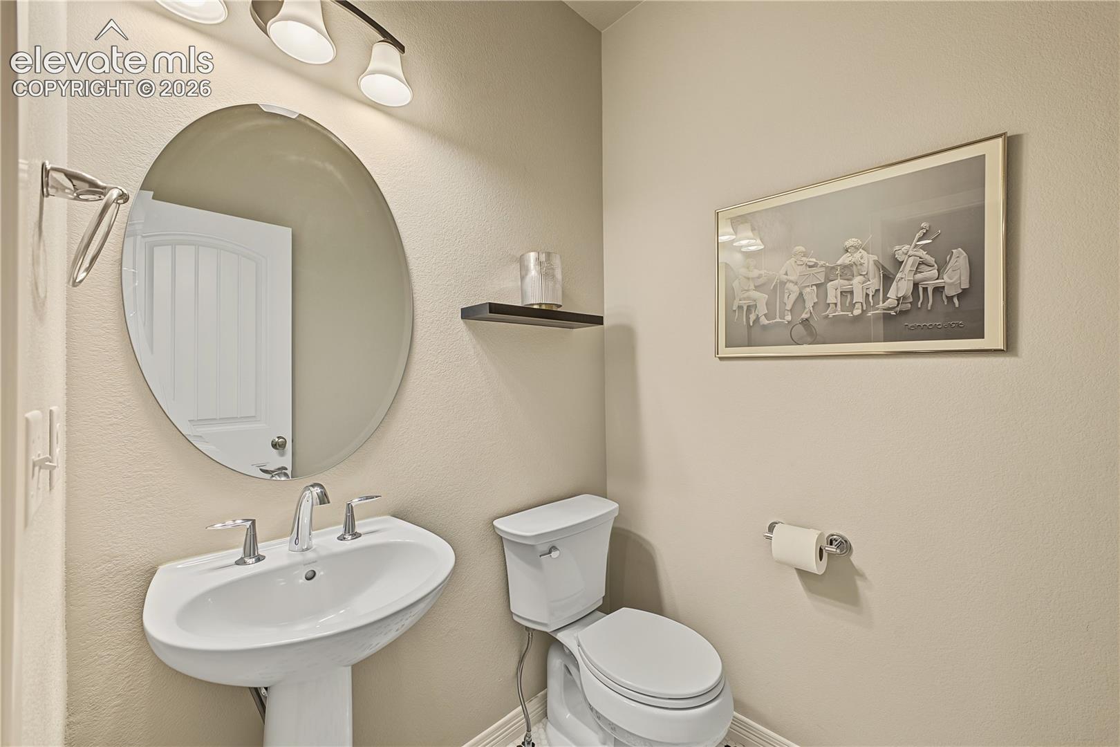 Convenient powder room provides a dedicated space for guests without the need to access the home’s private bathrooms.