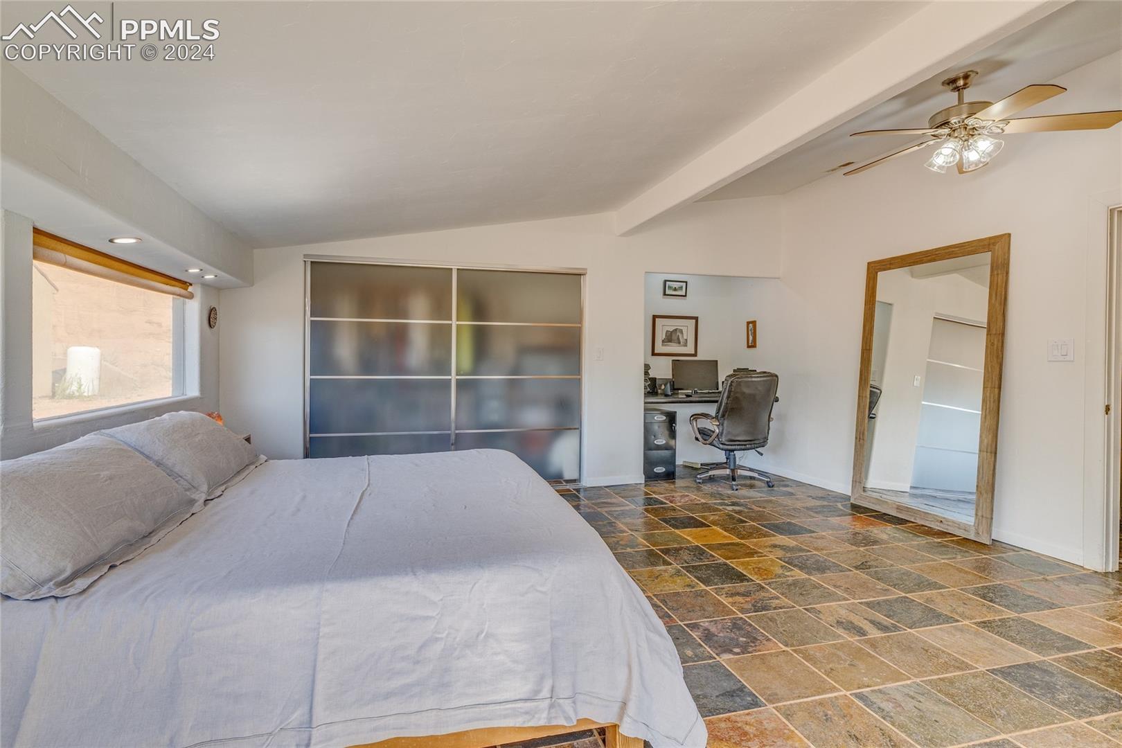 Bedroom with tile flooring, lofted ceiling with beams, and ceiling fan