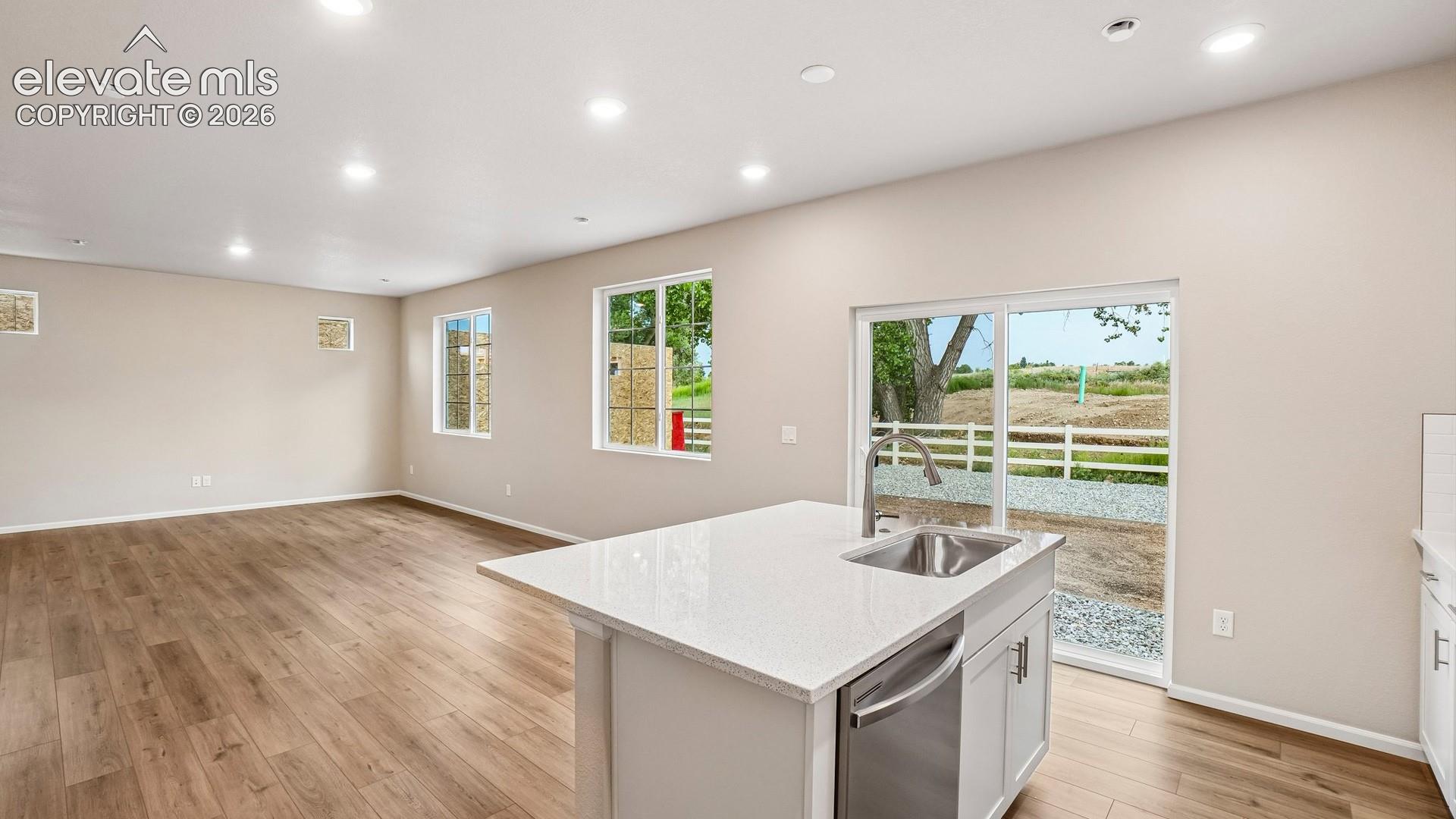 Open-concept living area with wood-finish flooring, recessed lighting, and ample natural light through multiple windows
*photos of a model home*