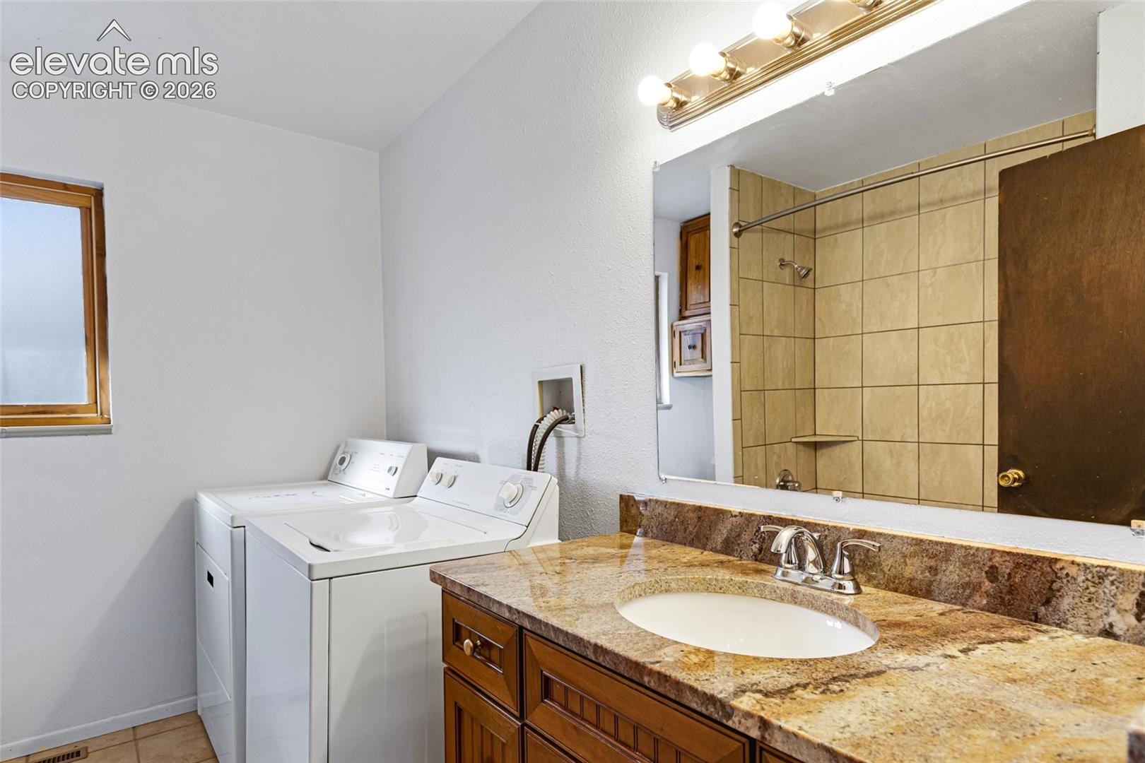 Bathroom featuring a vanity with a stone-finish countertop, undermount sink, and chrome faucet
