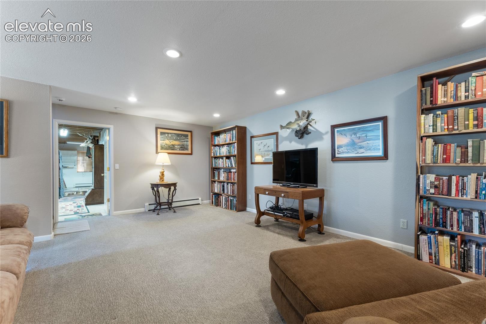 Spacious carpeted room featuring recessed lighting and built-in shelving