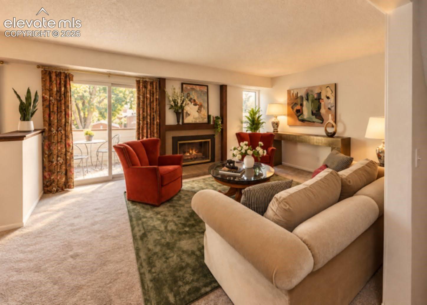 Living area featuring a floor-to-ceiling fireplace with wood surround and sliding glass doors leading to an outdoor space