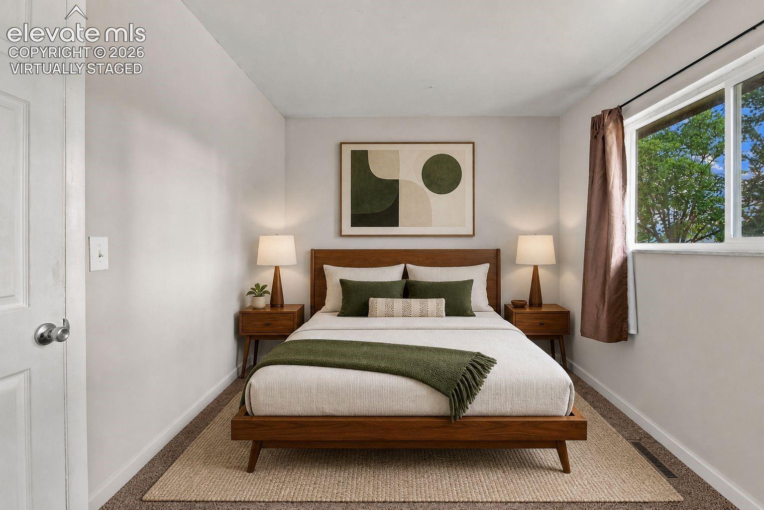 Main level bedroom with large window, carpet and closet space *virtually staged
