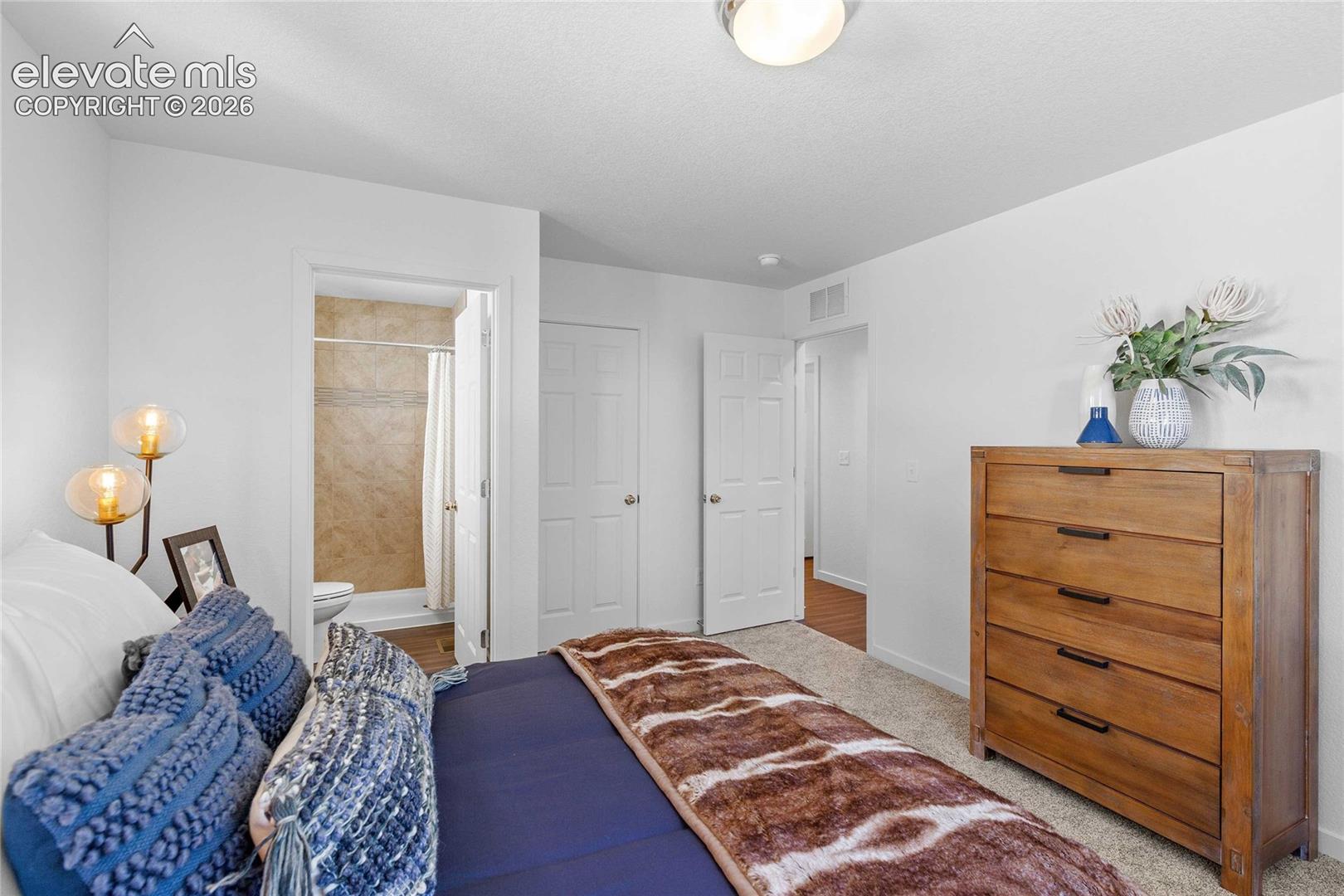 Carpeted flooring, white interior doors, and a bathroom with a tiled shower surround
*photos of a model home*