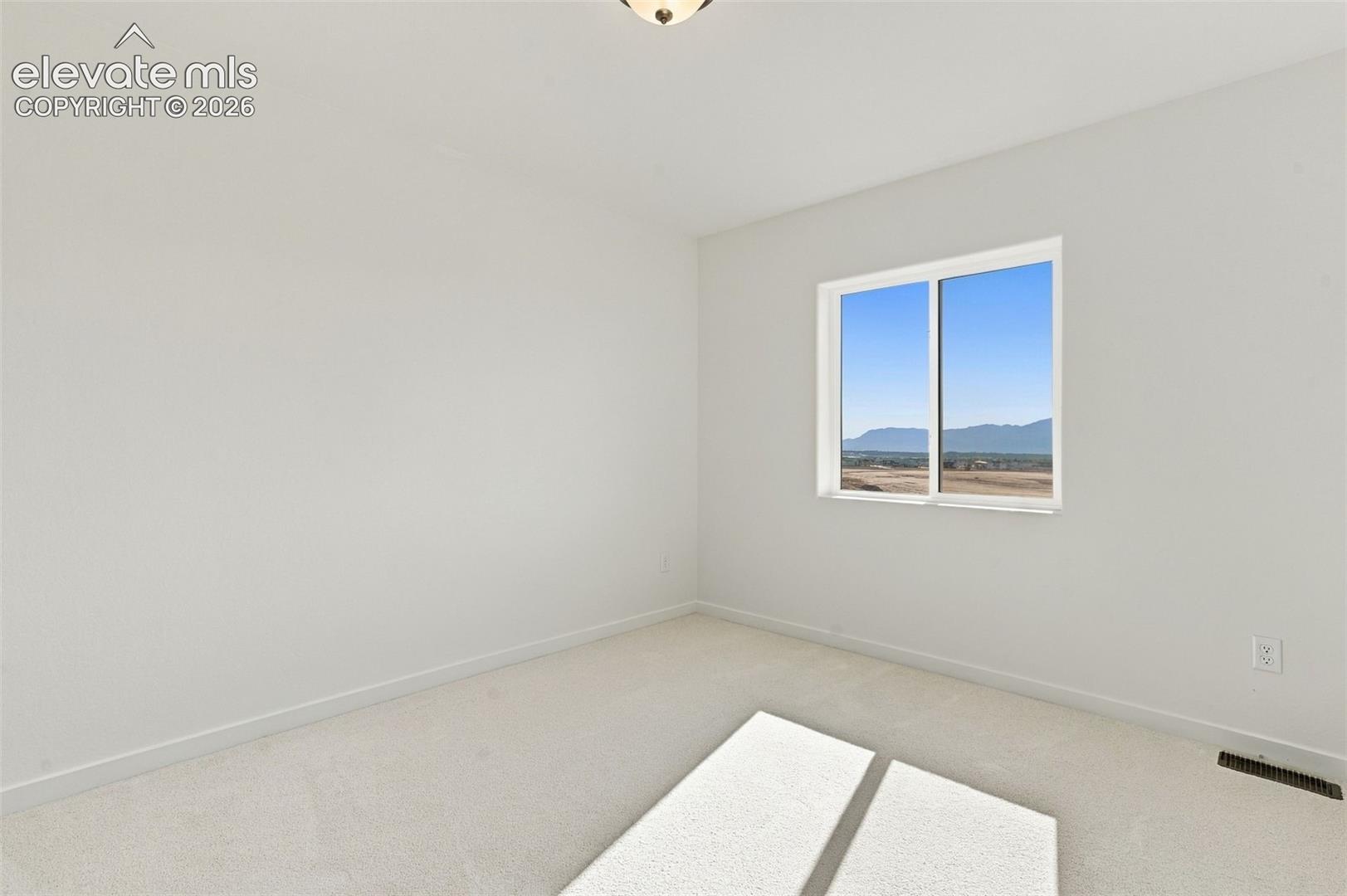 Neutral carpet flooring, white painted walls, and a fixed light fixture