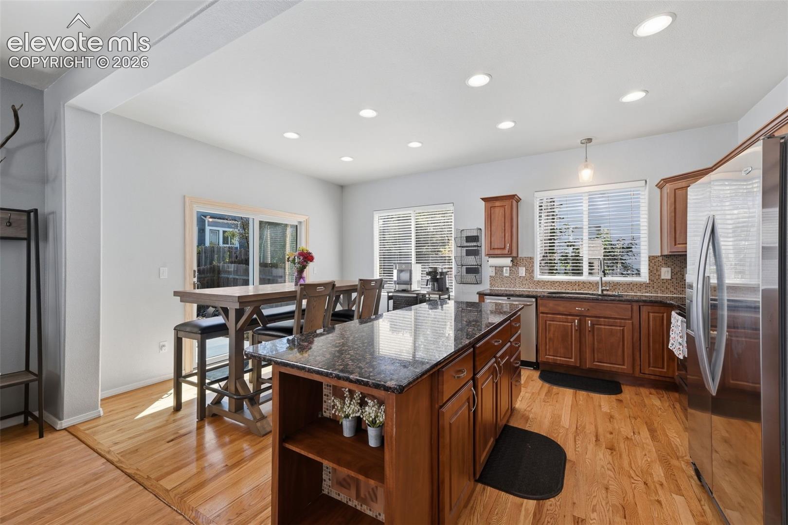 Kitchen featuring wood-finish flooring, recessed lighting, and a center island with a dark countertop