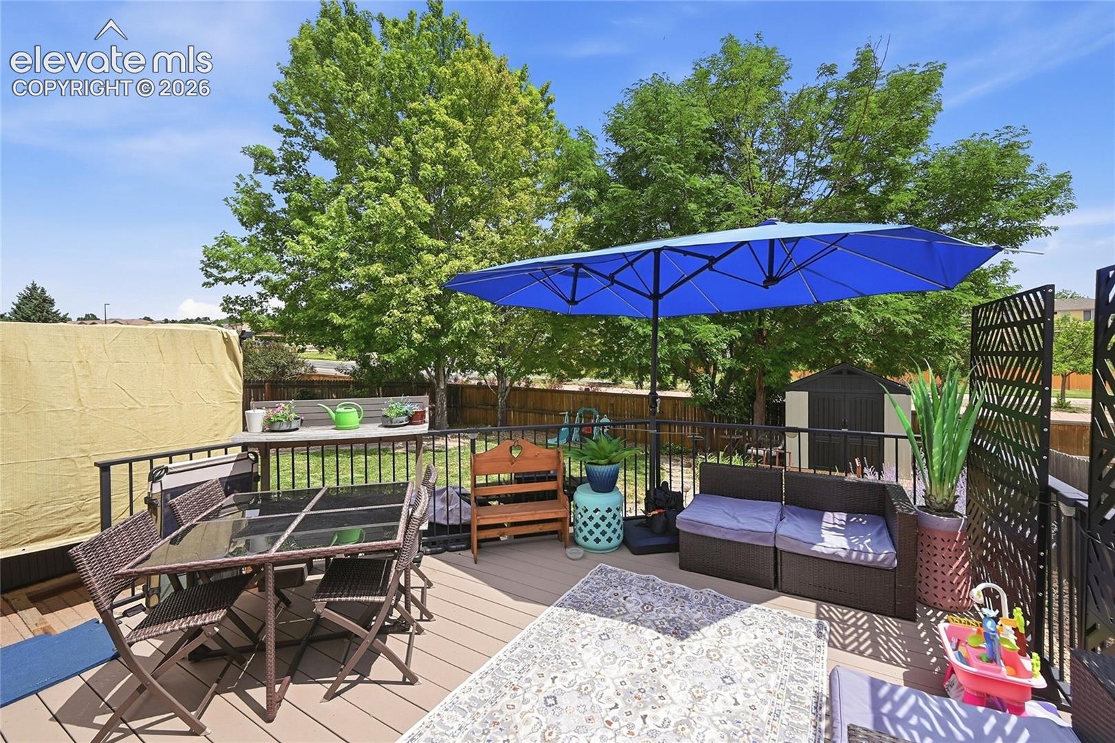 Elevated deck featuring composite decking, black metal railing, and decorative privacy screening