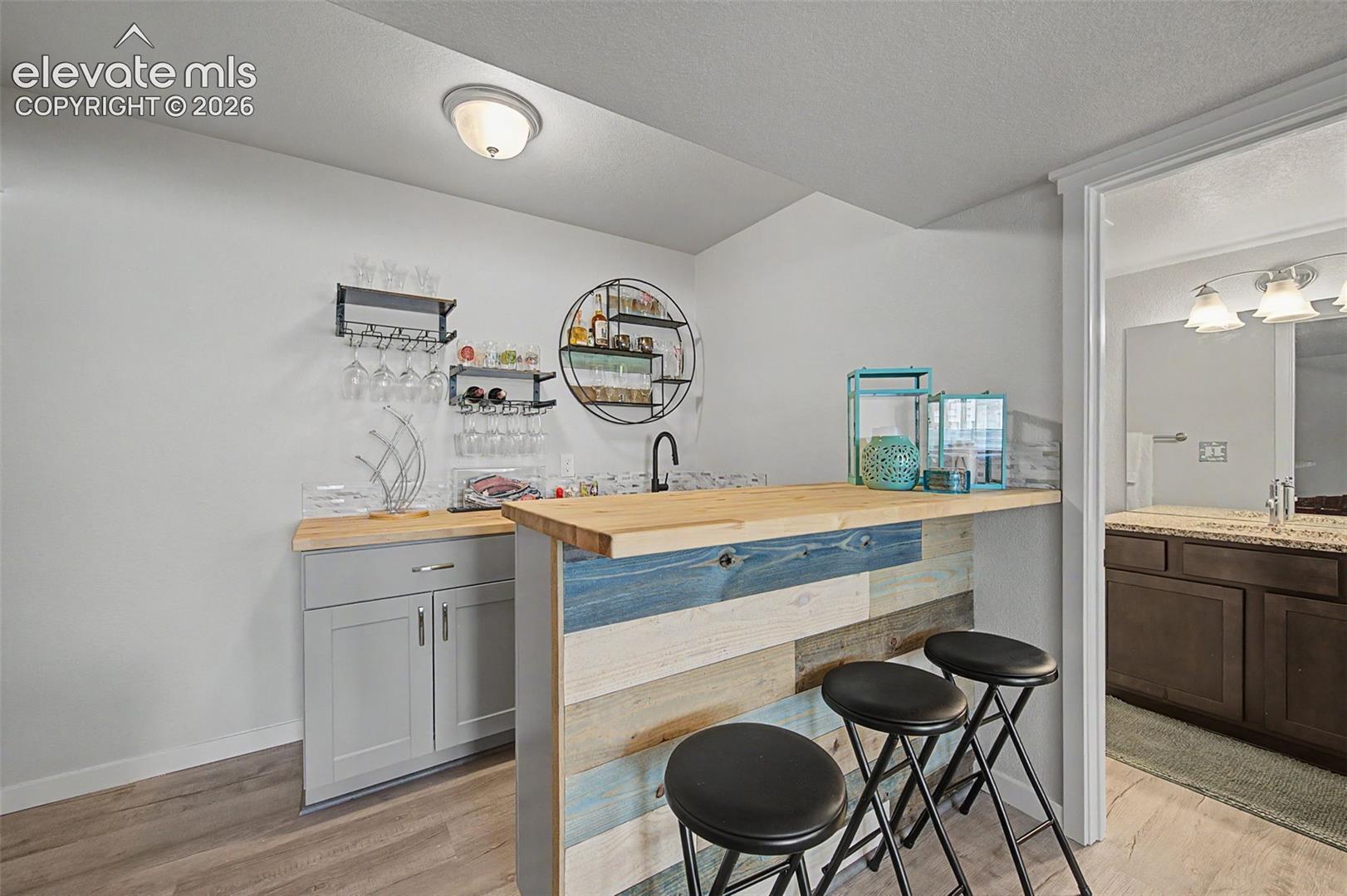 Wet bar in basement family room comes equipped with a wine fridge.