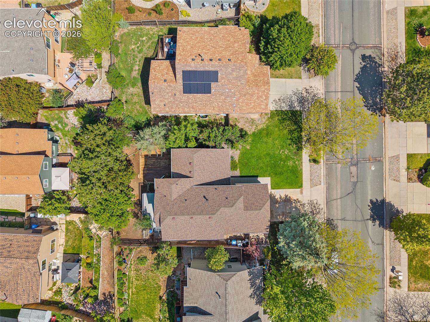 Aerial perspective of a residential street featuring paved roads and sidewalks