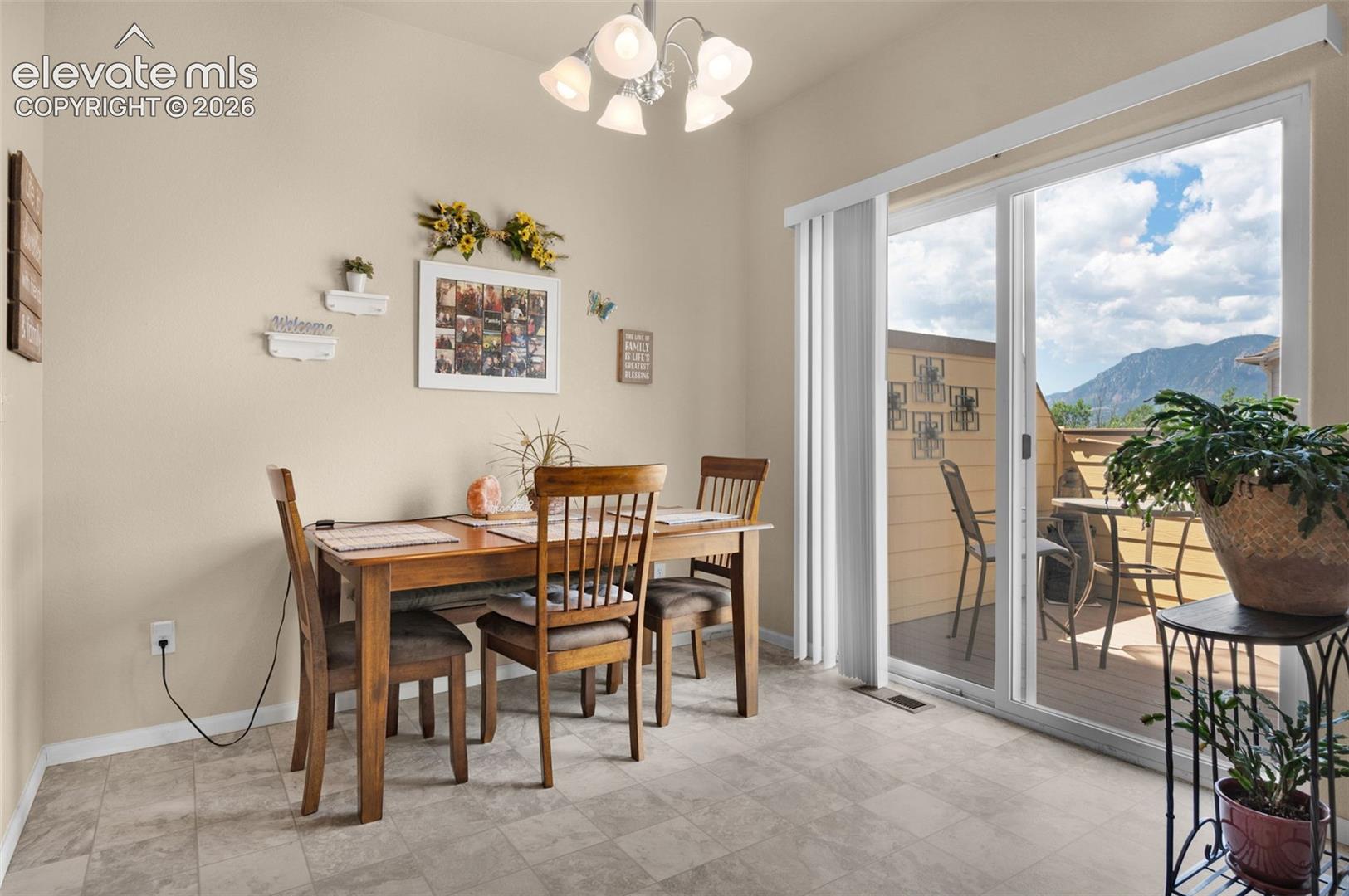 Sliding glass doors open to an outdoor deck with mountain scenery
