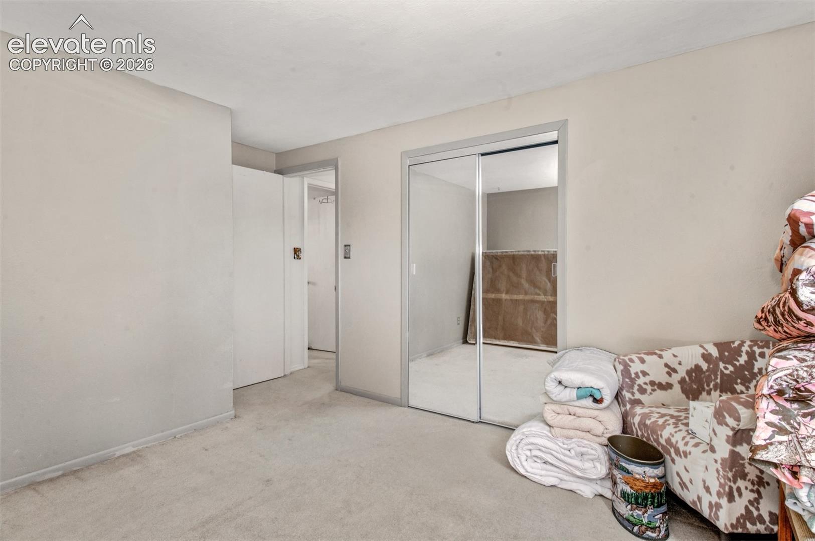 Bedroom two:Mirrored closet doors and neutral carpeting