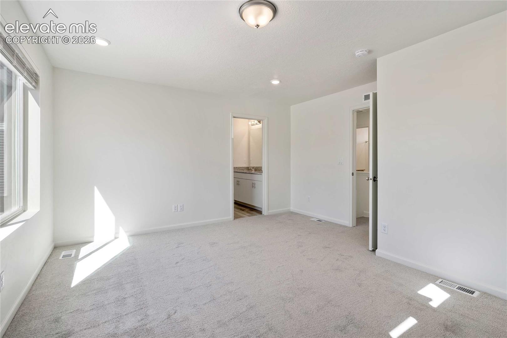 Carpeted flooring, recessed lighting, ceiling-mounted light fixture, single window, white walls
*photos of a model home*