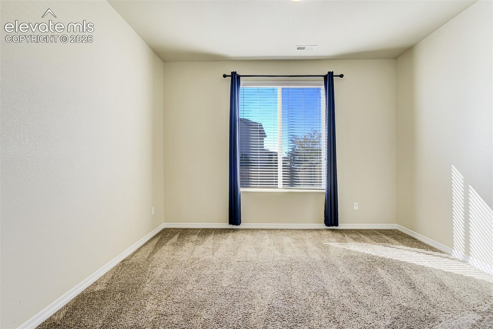 Neutral wall finishes, textured carpeting, window with blinds, and recessed lighting