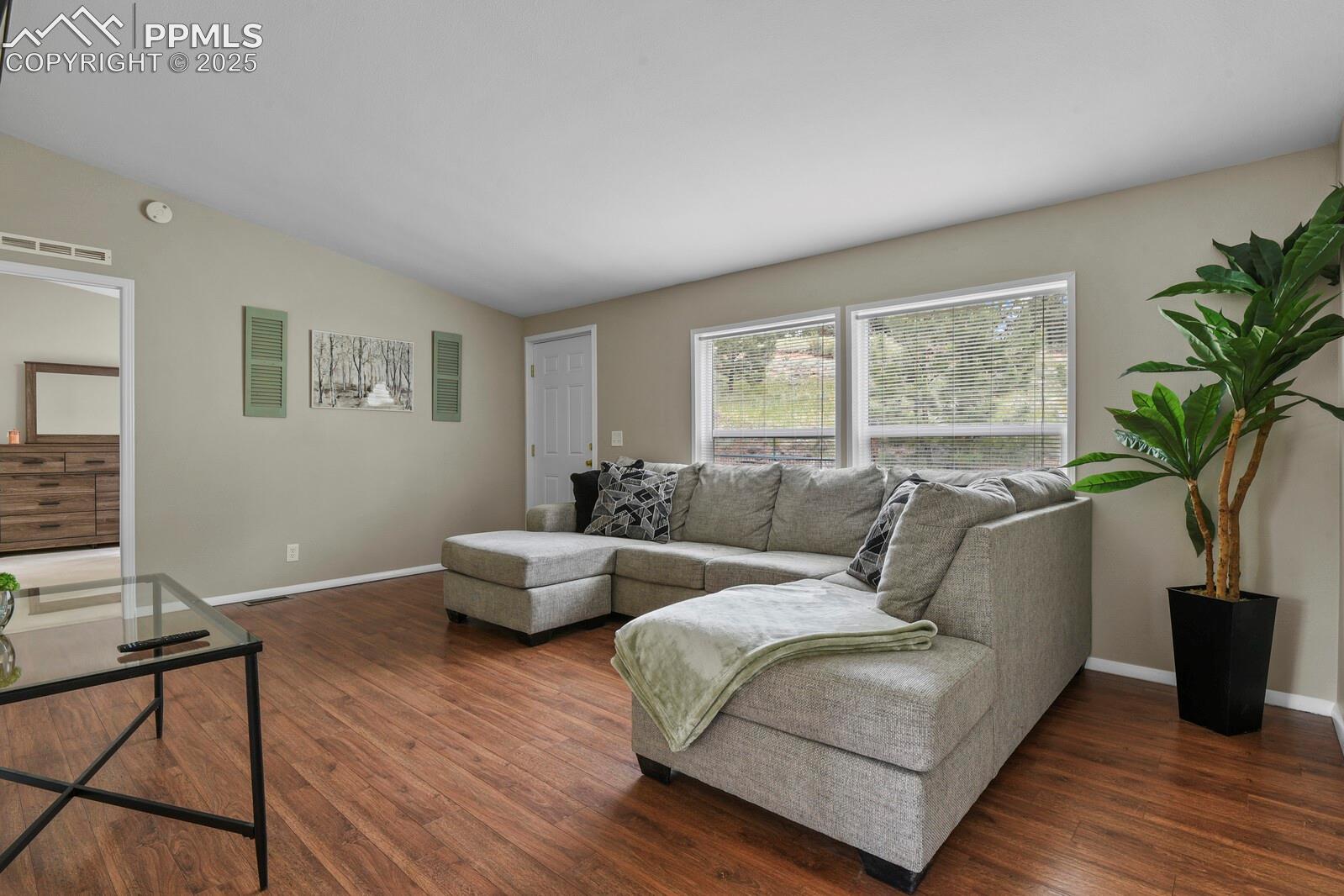 Living area featuring dark wood finished floors and lofted ceiling