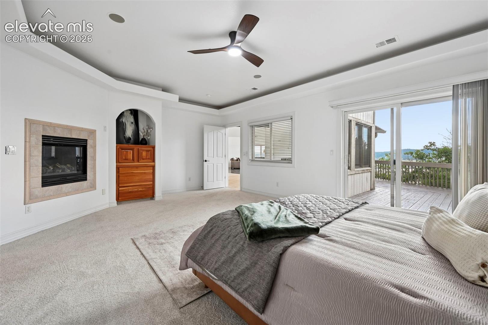 Spacious room featuring a contemporary ceiling fan, recessed lighting, and tray ceiling details
