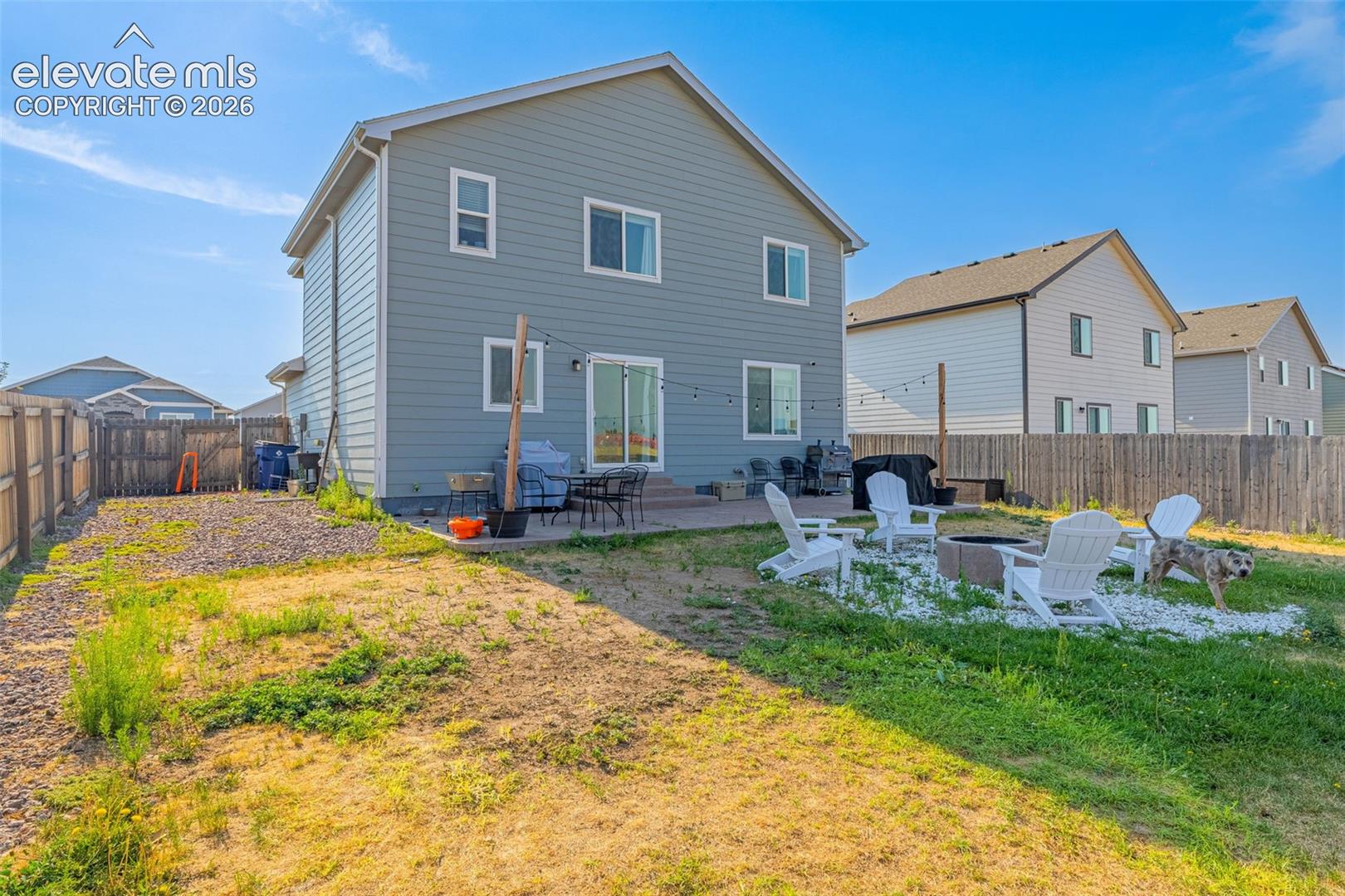 Rear exterior featuring a sliding glass door, patio area, and fenced backyard