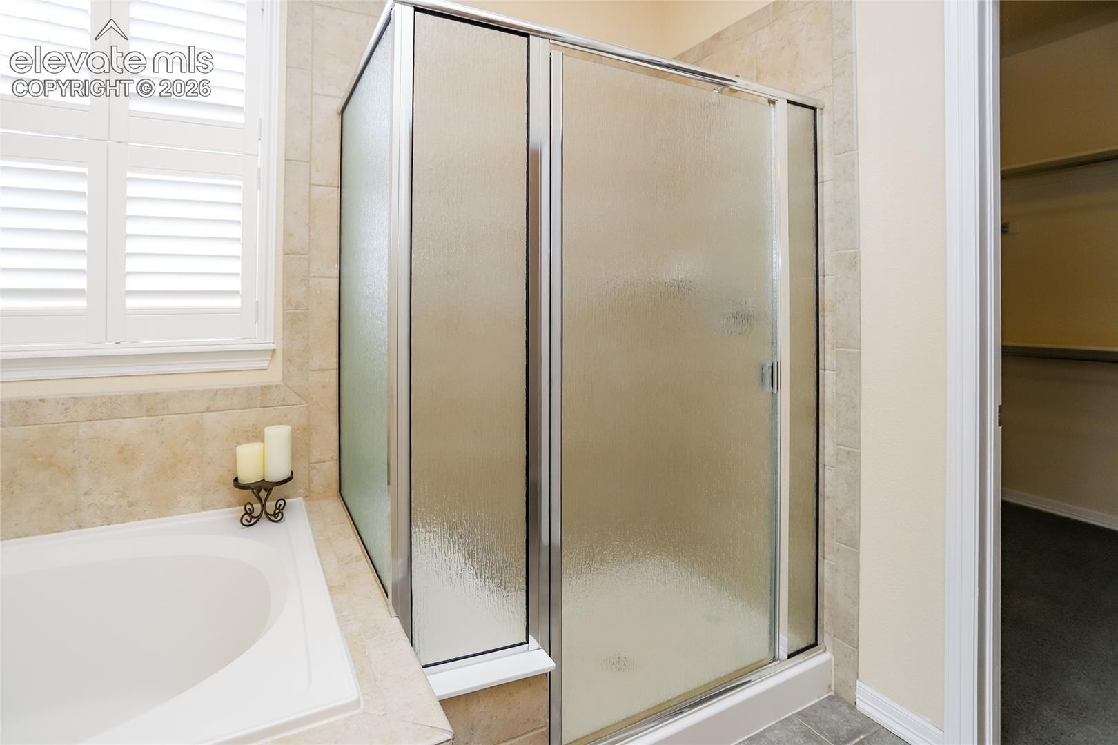 Oversized shower with seating and textured glass.