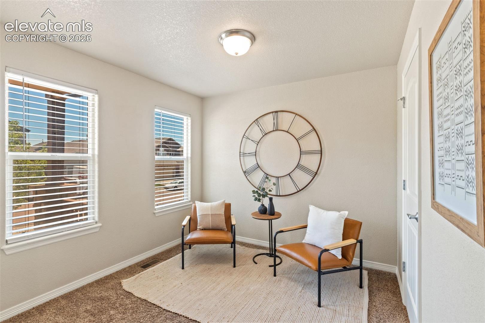 Neutral-toned room featuring a flush-mount ceiling light and two windows with horizontal blinds