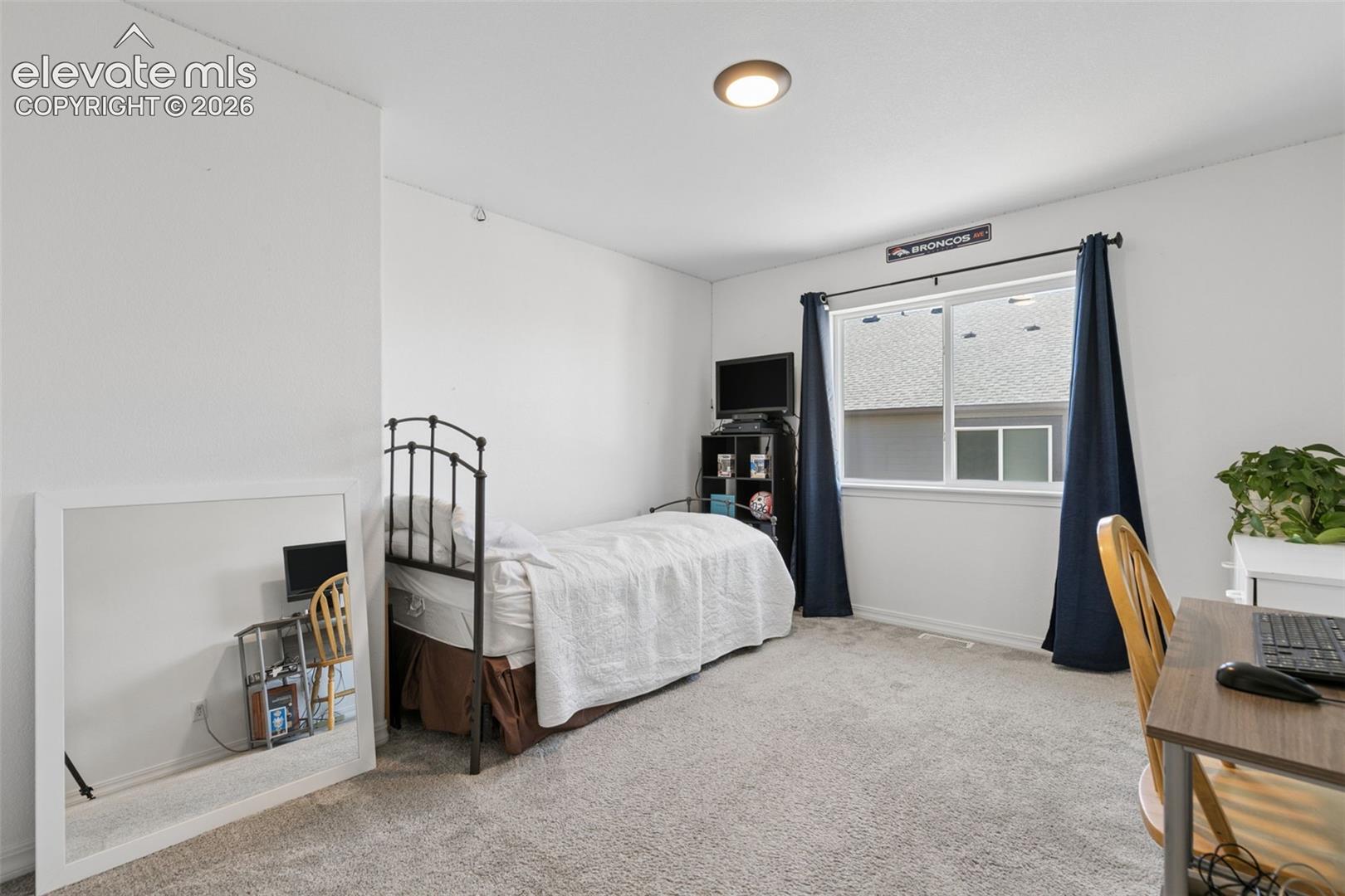 Carpeted flooring, recessed ceiling lighting, and a window with blinds