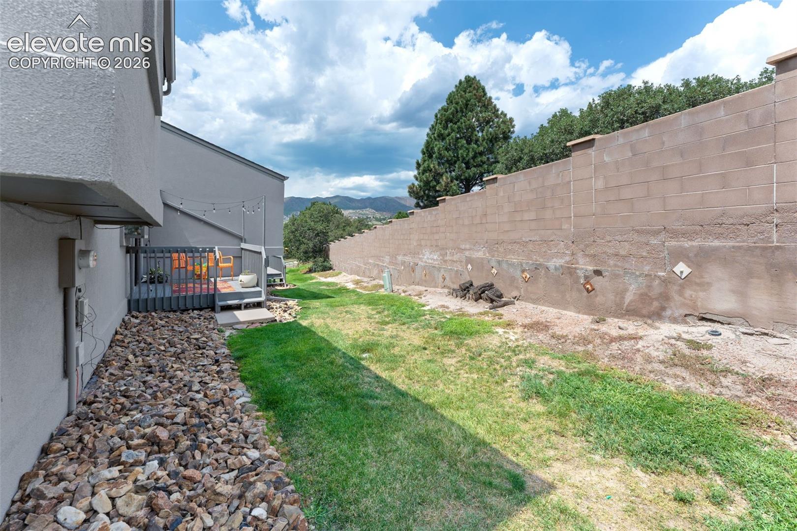 Outdoor patio with a privacy fence and a gravel landscaping strip