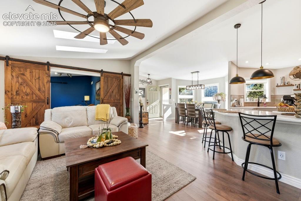 Wood-finish flooring throughout, with a skylight and a ceiling fan with integrated lighting