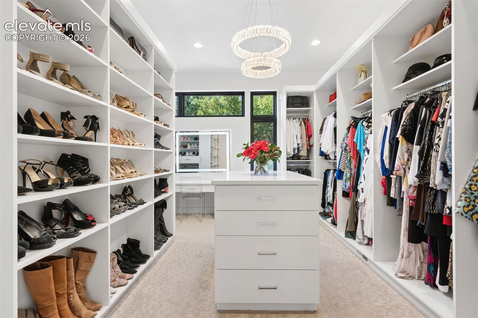 A stunning, boutique-inspired dressing room with custom cabinetry, a central island, exquisite lighting, and beautifully curated displays. A private space where luxury, organization, and everyday glamour come together.
