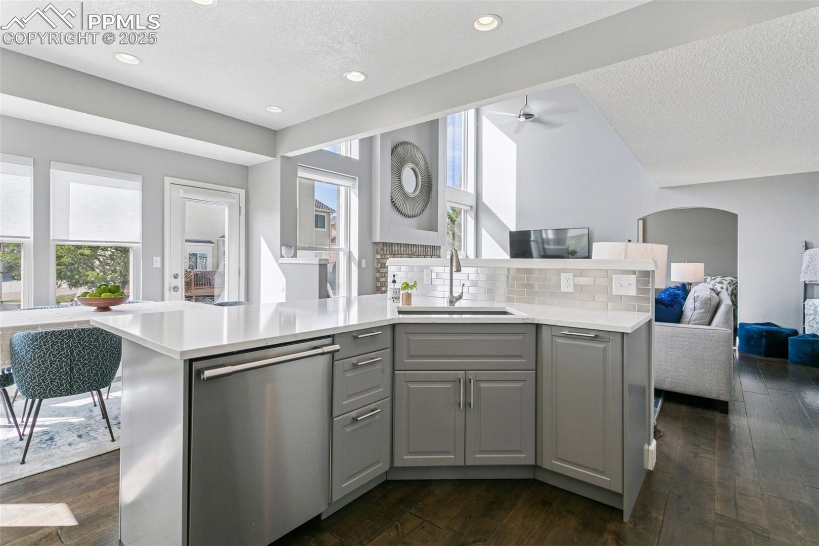 Large kitchen island w/quartz counters, farmhouse sink and a stainless steel dishwasher!