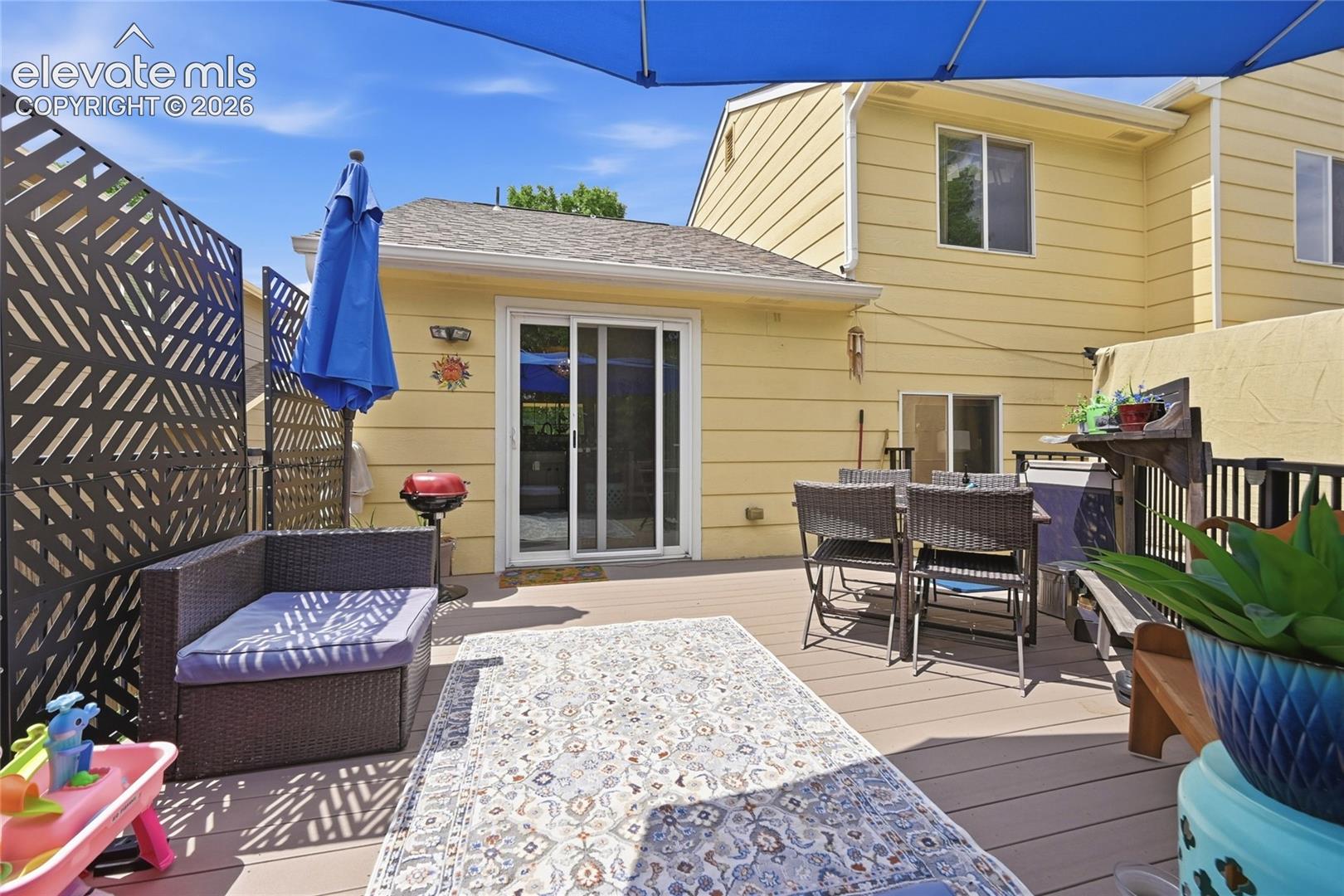 Exterior deck featuring composite decking, black metal railings, and a decorative geometric privacy screen