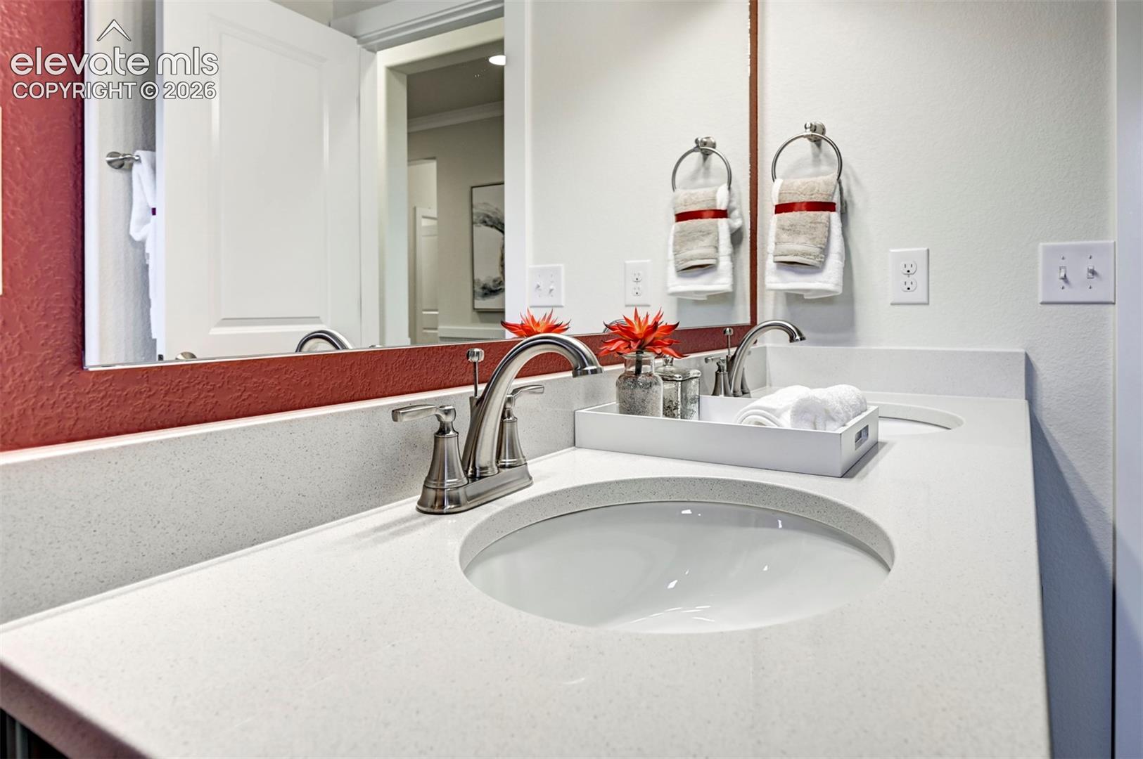 Double vanity with integrated sinks, brushed nickel fixtures, and light-toned countertops