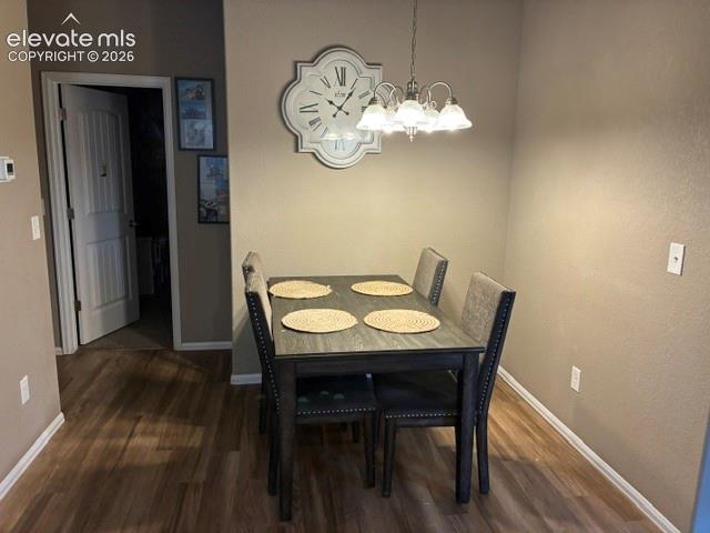 Wood-finish flooring, multi-light hanging chandelier, and interior paneled door
