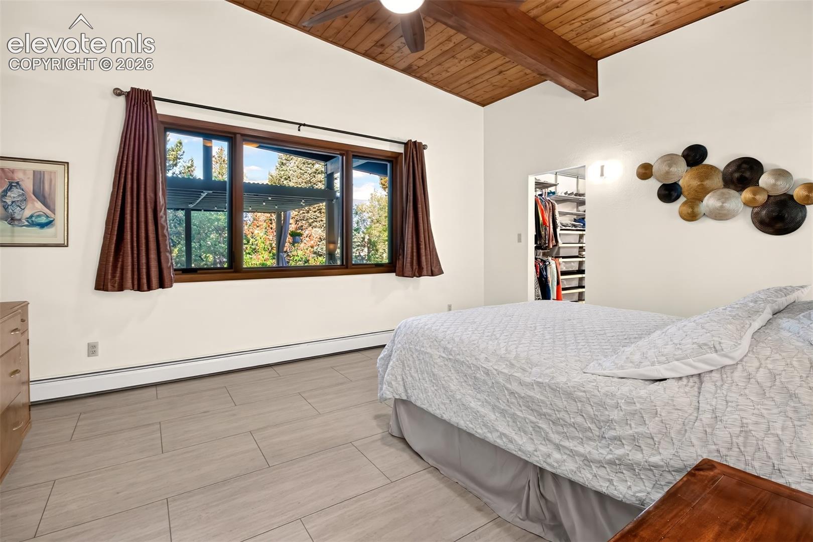 The primary bedroom has windows overlooking the patio