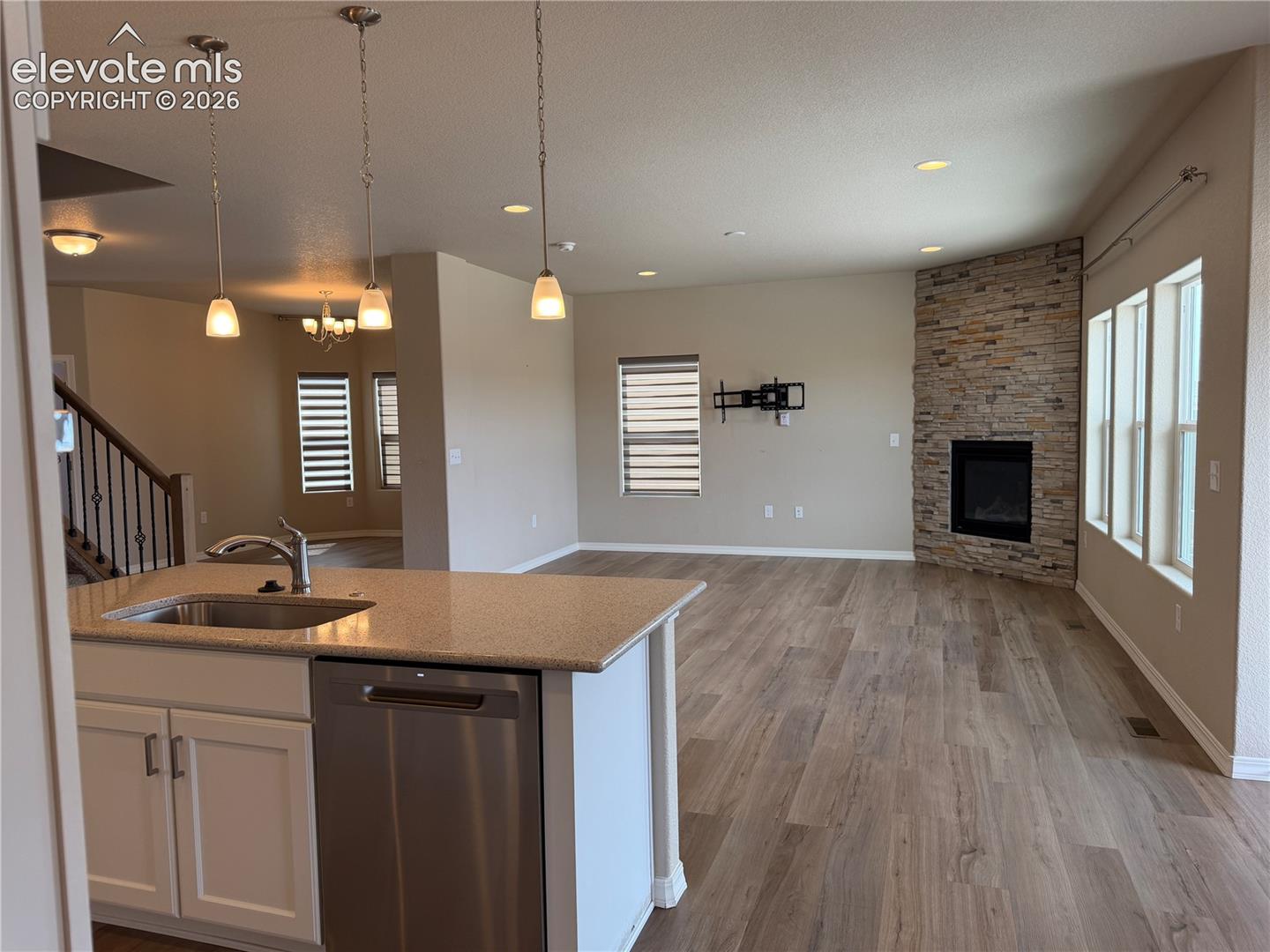 Kitchen island with integrated sink, stainless steel dishwasher, and stone-finish countertop