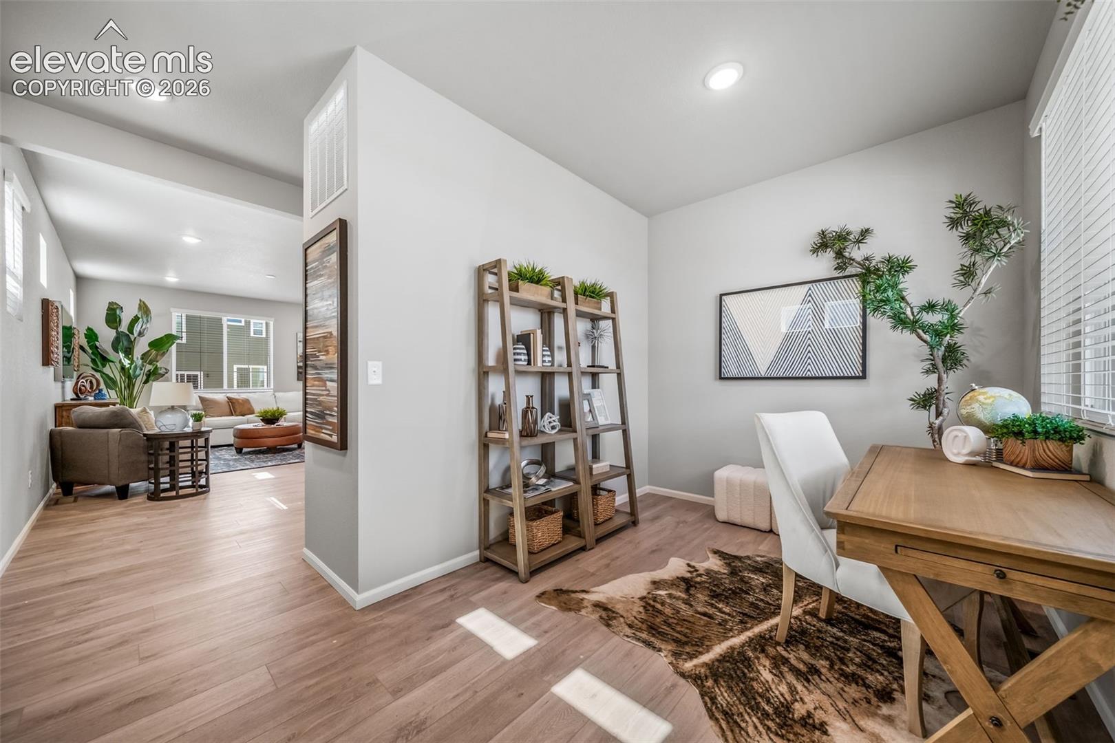 Wood-finish flooring throughout, recessed lighting, and a window with blinds
*photos of a model home*