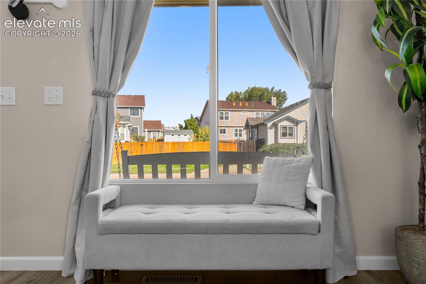 Window with light-colored curtains and a built-in window bench