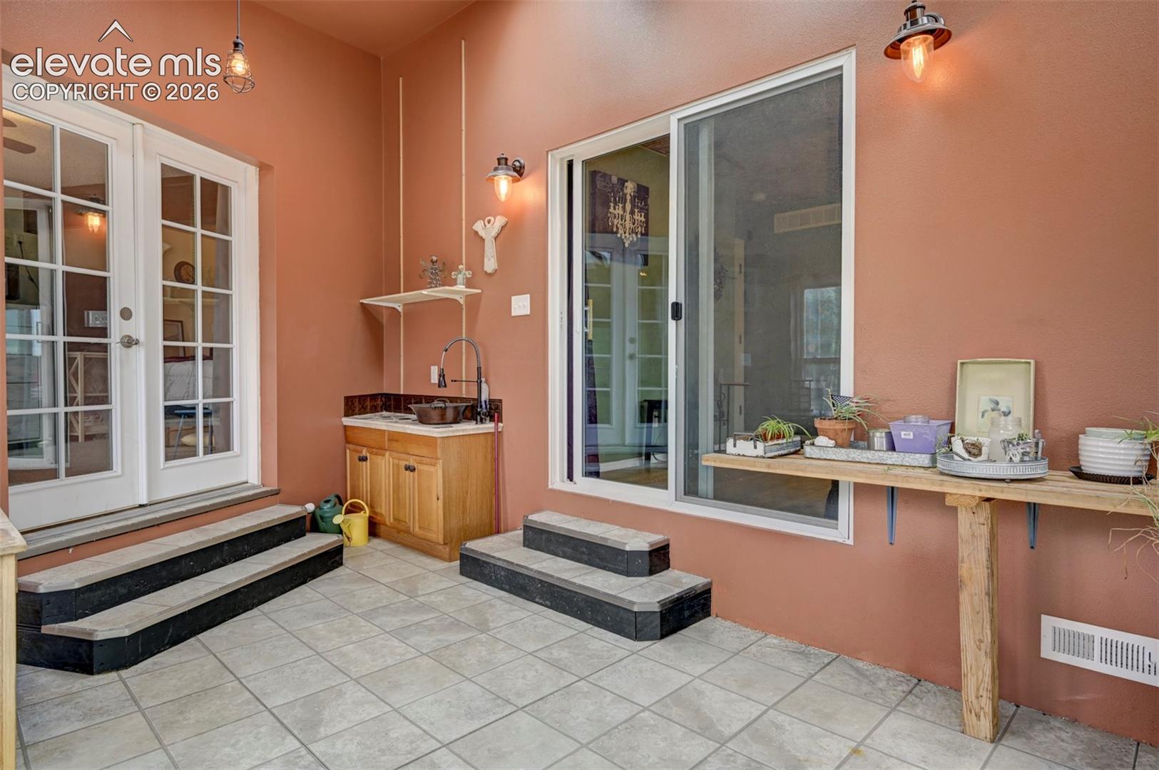Tiled flooring with a built-in wet bar, wood-finish cabinetry, and a sliding glass door