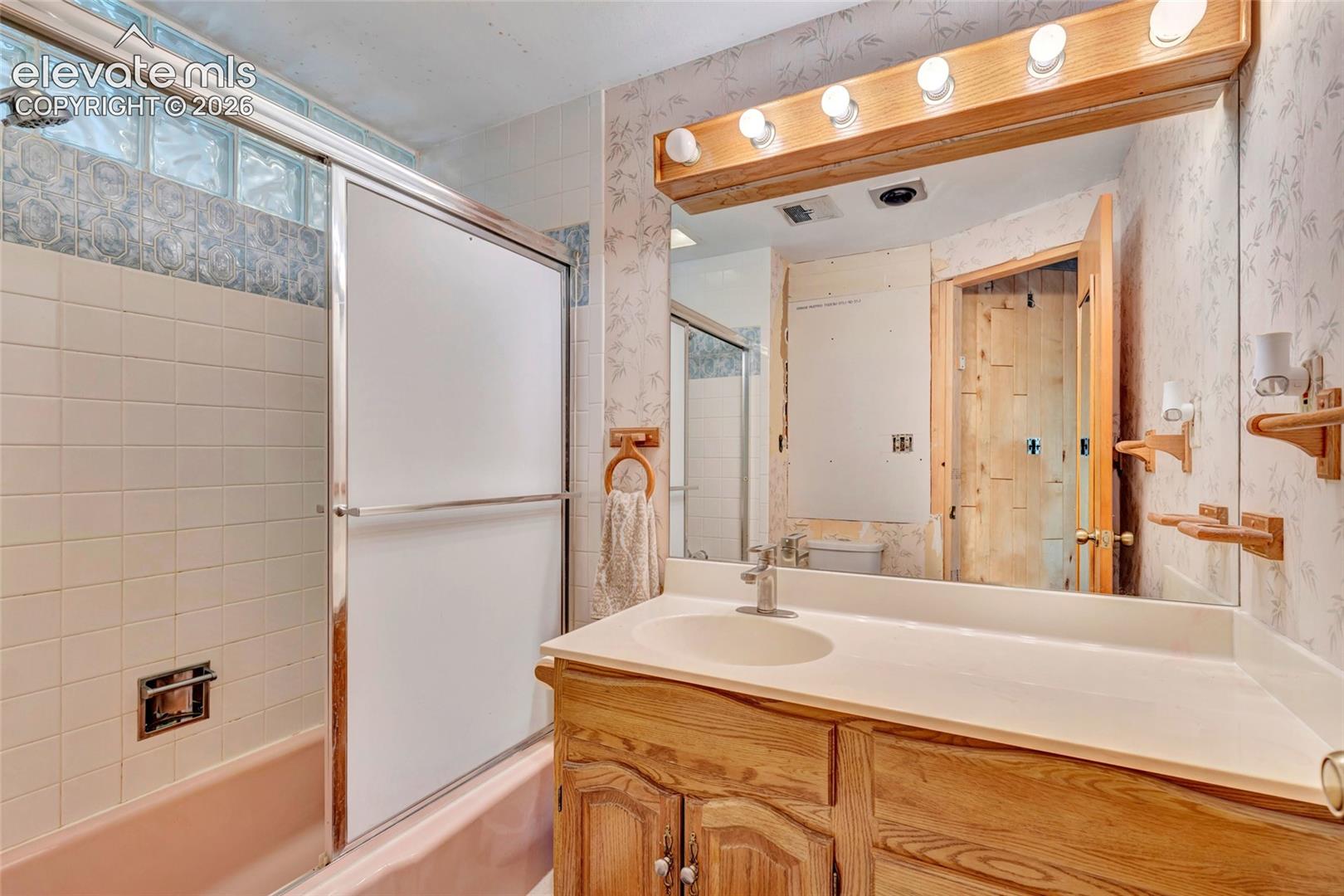 Wood-finish vanity with an integrated sink and mirror
