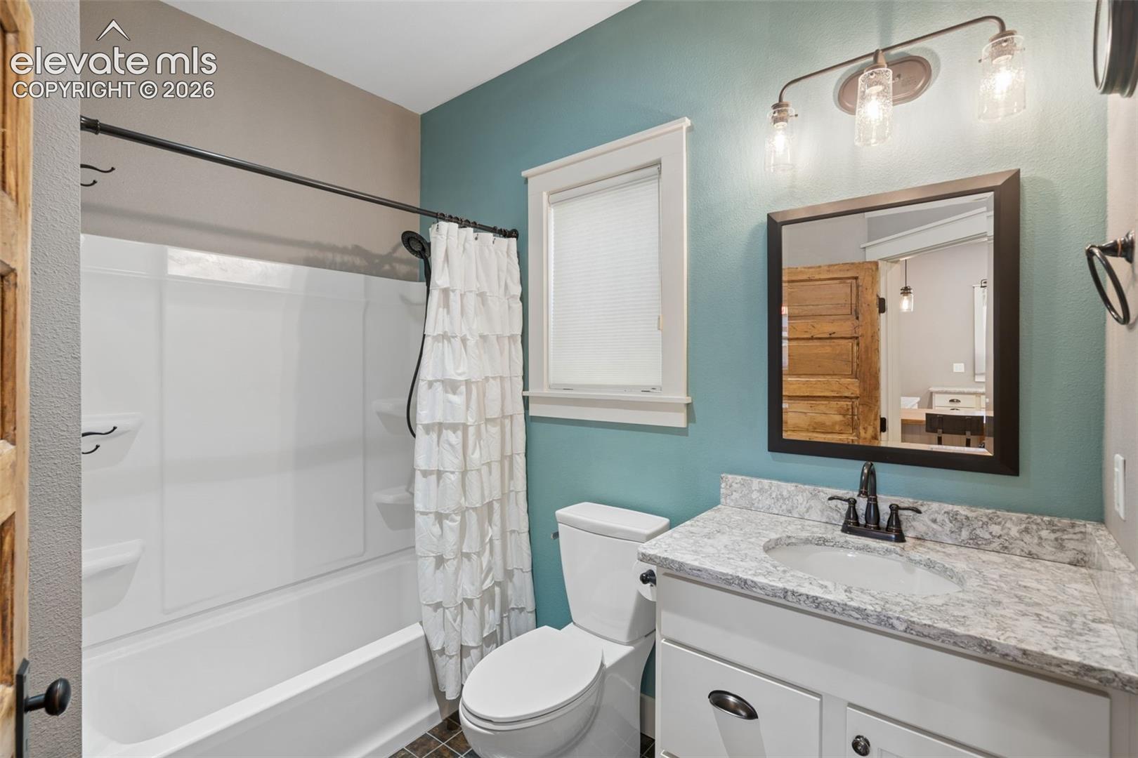 Bathroom with tile floor and granite countertop on vanity