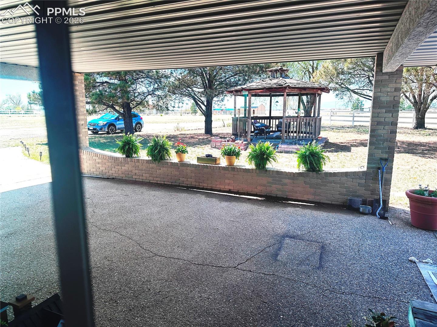 Gazebo shown nestled in the trees west of covered entryway.