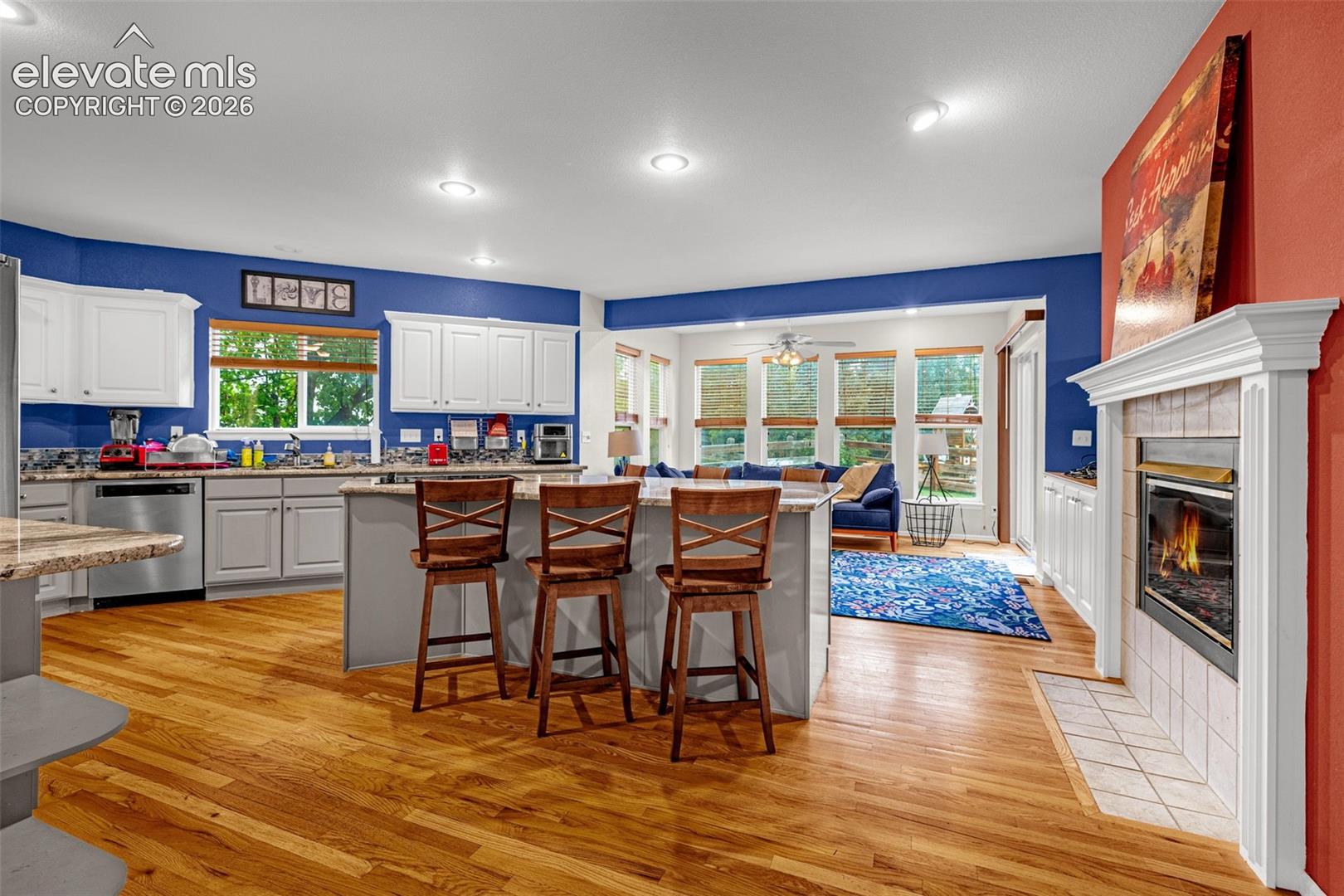Kitchen with light wood-finish flooring and white cabinetry